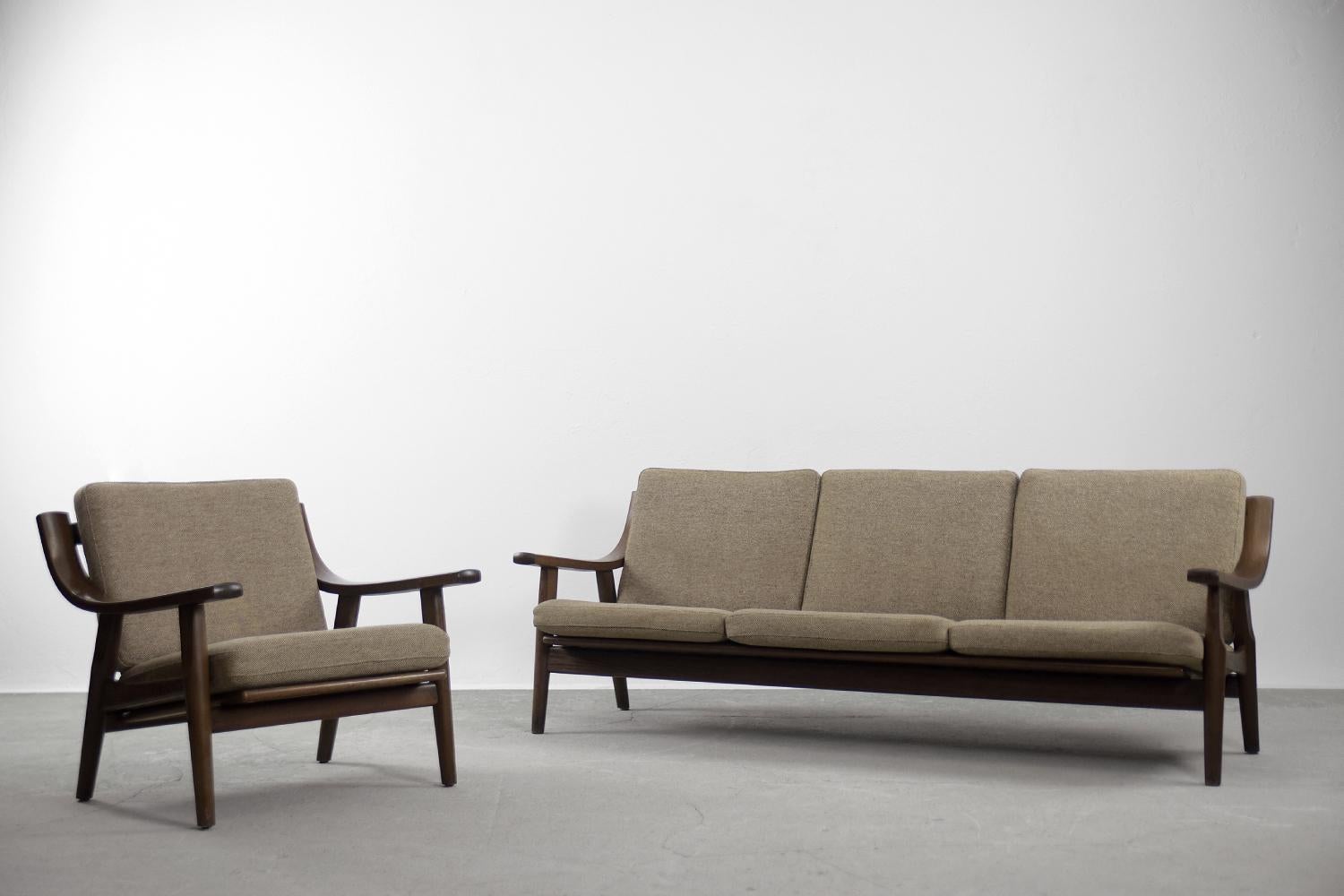 This elegant lounge set consist of a three-seater sofa and an armchair. The set was designed by Hans J. Wegner for the Getama Gedsted in Denmark during the 1960s. This is the GE-530 model. The frame is made of solid oak wood in dark brown. The frame