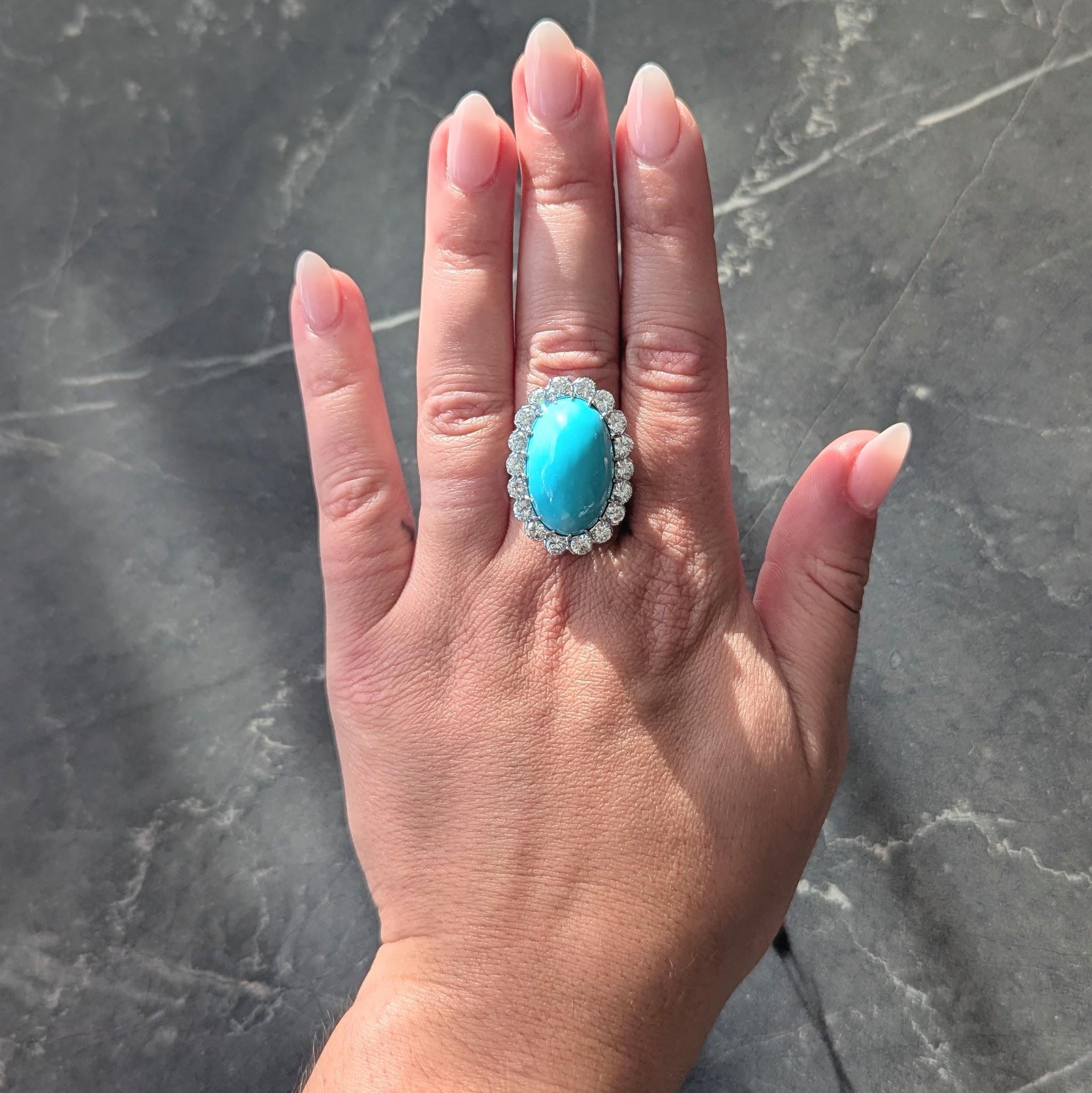 In der Mitte ein ovaler Türkiscabochon von 22,0 x 15,0 mm
Opakes, helles Rotkehlchenblau mit mäßiger Sättigung
Gefasst über Talon-Pongs mit einem Diamant-Halo-Rahmen
Rund im Brillantschliff und mit Fischschwanzzacken besetzt
Mit einem Gesamtgewicht