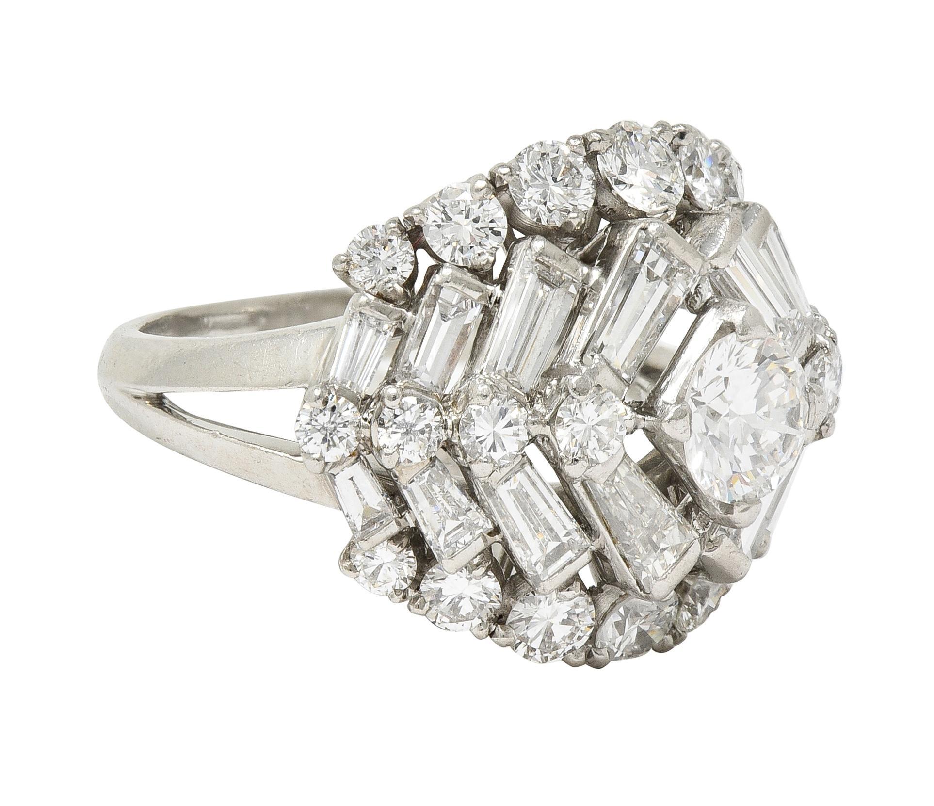 Centering a transitional cut diamond weighing approximately 0.57 carat total 
G color with VS2 clarity - prong set with a stepped bombé shaped surround 
Bar and prong set throughout with transitional and baguette cut diamonds
Weighing approximately