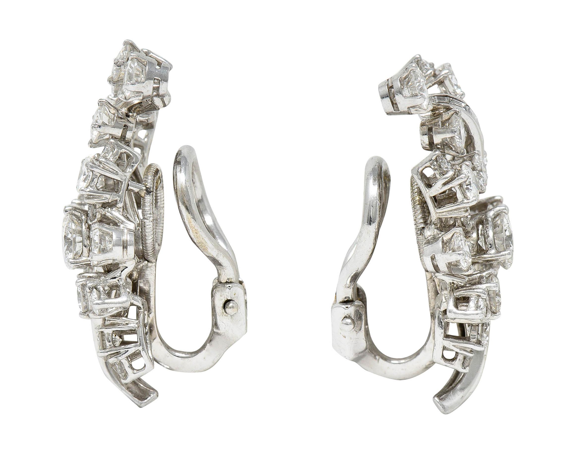 Dimensional spray style earrings are comprised of ribbon-like tendrils and navette clusters

Set throughout by round brilliant and baguette cut diamonds

Weighing in total approximately 3.85 carats - F to G color with primarily VS clarity

Completed