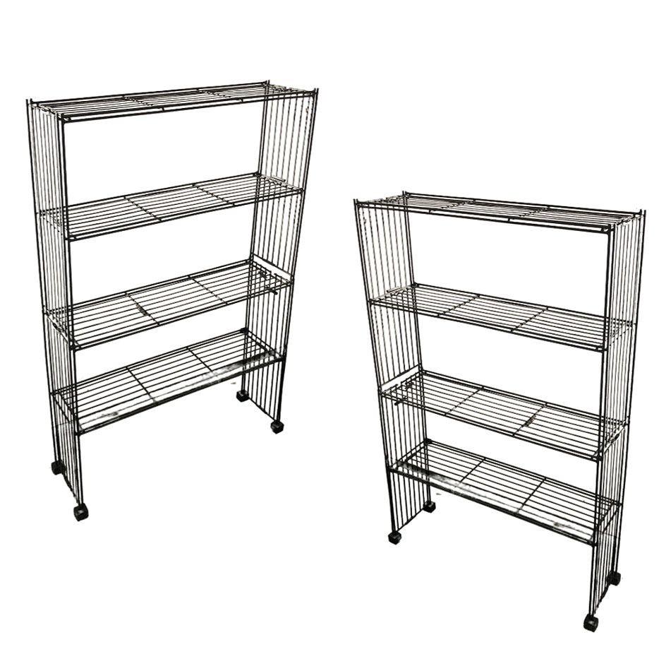 Original pair of Mid-Century iron wire 4-tier art display shelf bookshelfs each featuring a welding frame made from hundreds of black iron rods sculpted into a geometric shape. The cubist-like shape rests on 4 square wooden feet.

The infusion of