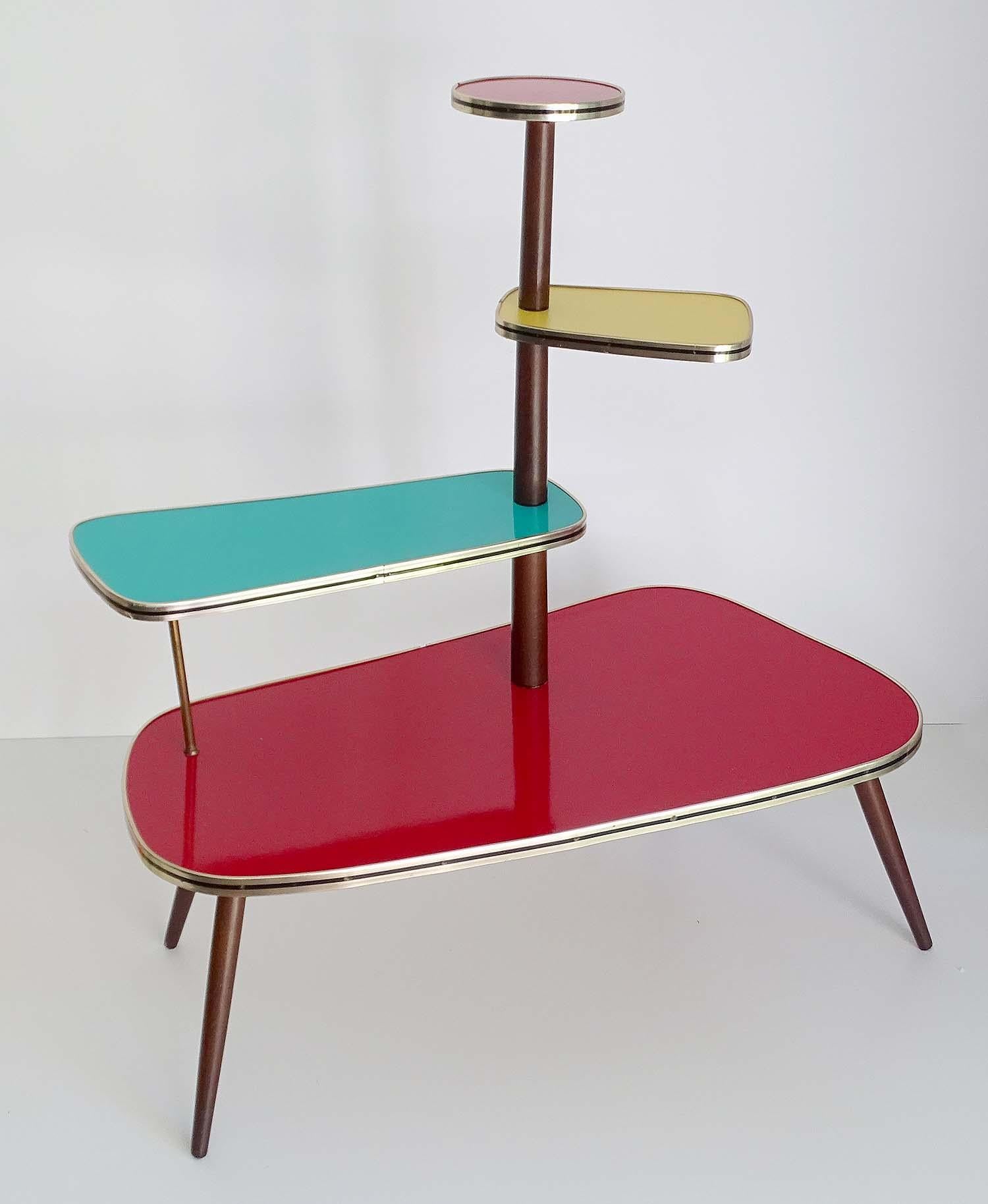 Stupendous large vintage tripod kidney Mid-Century Modern 1950s-1960s flower / plant stand 
A multilevel colored flower table/plant stand, it has 1 great plate and 3 smaller plates, made out
of wood with a bright colored laminate and brass / black
