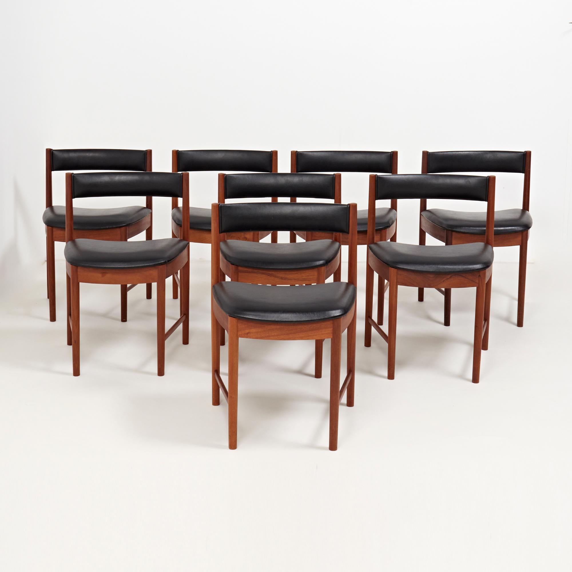 Designed by Scottish furniture designer A. H. McIntosh, this set of 4013 dining chairs are a Classic example of Mid-Century Modern furniture. 

The set of 8 chairs are crafted from teak wood with the original black leatherette upholstery on the