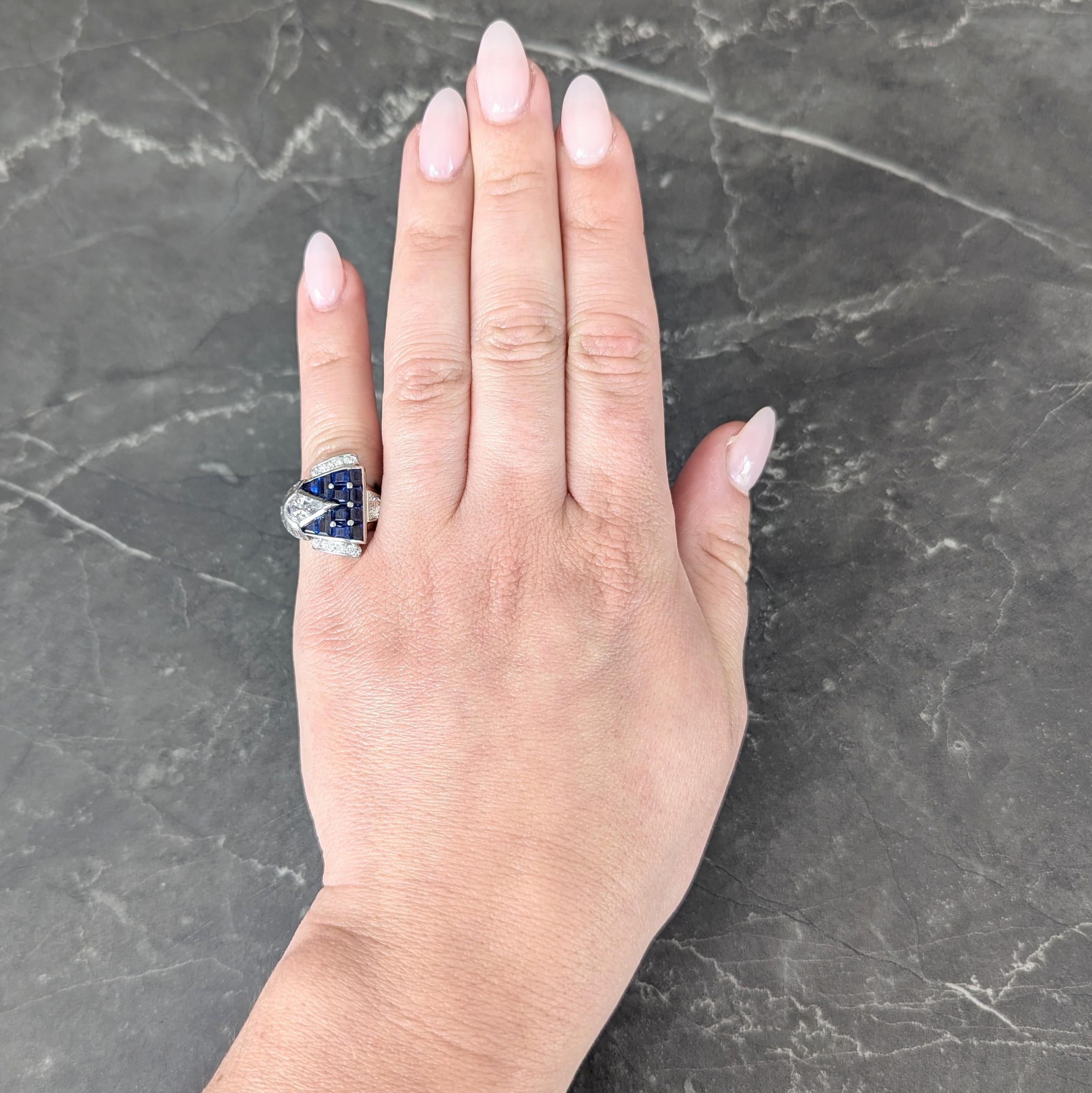 Designed as a stylized buckle motif ring with dimensionally geometric components
Featuring a pendulum cut diamond as prong - weighing approximately 0.85 carat
H color with VS2 clarity - set in semi-bezel with fanning semi-halo
Comprised of baguette