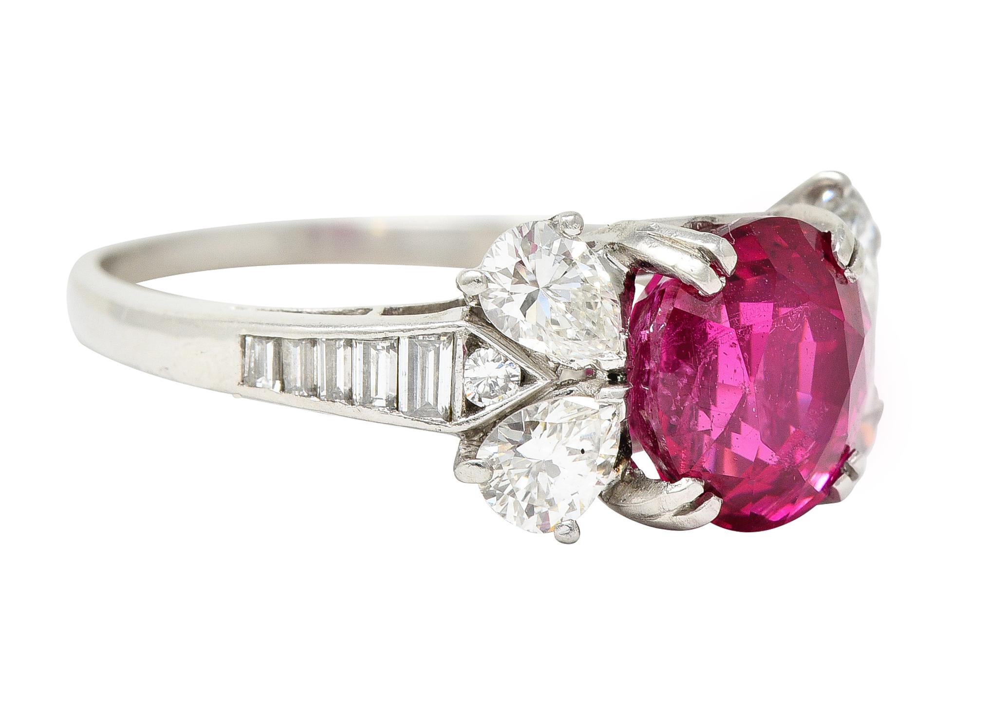 Centering an oval-cut spinel weighing 3.08 carats - transparent bright pinkish-red in color
Natural Burmese in origin with no indication of heat treatment
Set with split prongs in a basket and flanked pear cut diamonds arranged as bowtie motif
Prong