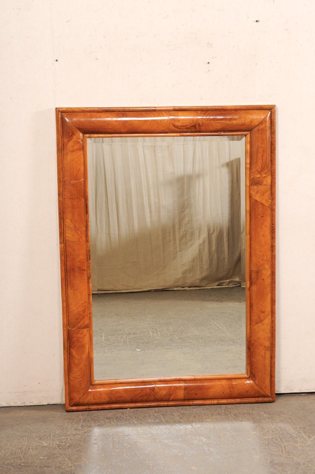 Uno specchio da parete americano di buone dimensioni risalente alla metà del XX secolo. Questo specchio vintage ha una cornice in legno modellato di forma rettangolare. Il legno di tonalità media ha una venatura e un movimento meravigliosi. Si prega