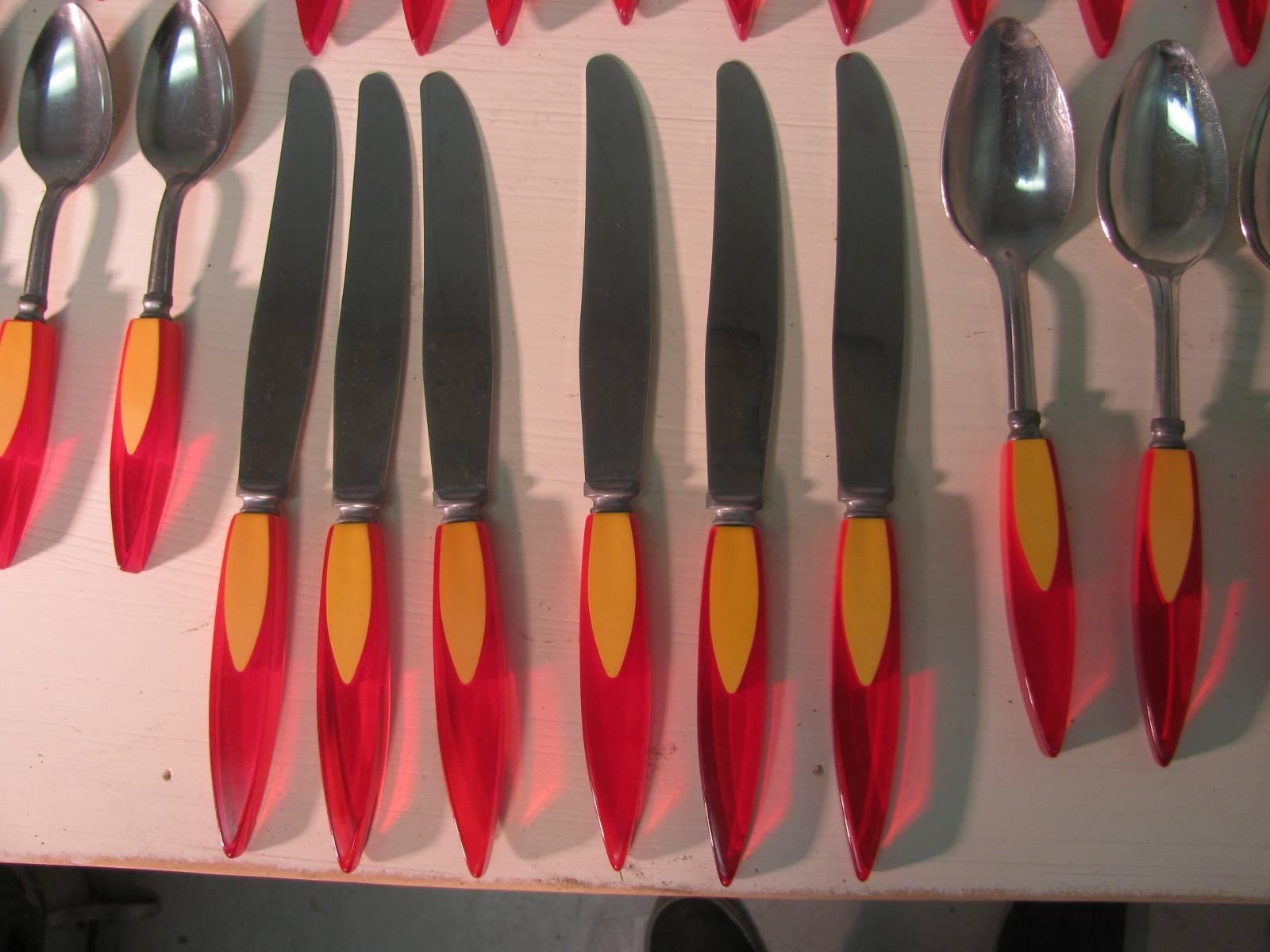 Amazing set of bakelite, catalin flatware from the early 1950s. In the shape and color of a flame. Like new condition, service set includes 12 knives, 12 soup spoons, 12 forks, 12 teaspoons. Fitted storage box included.