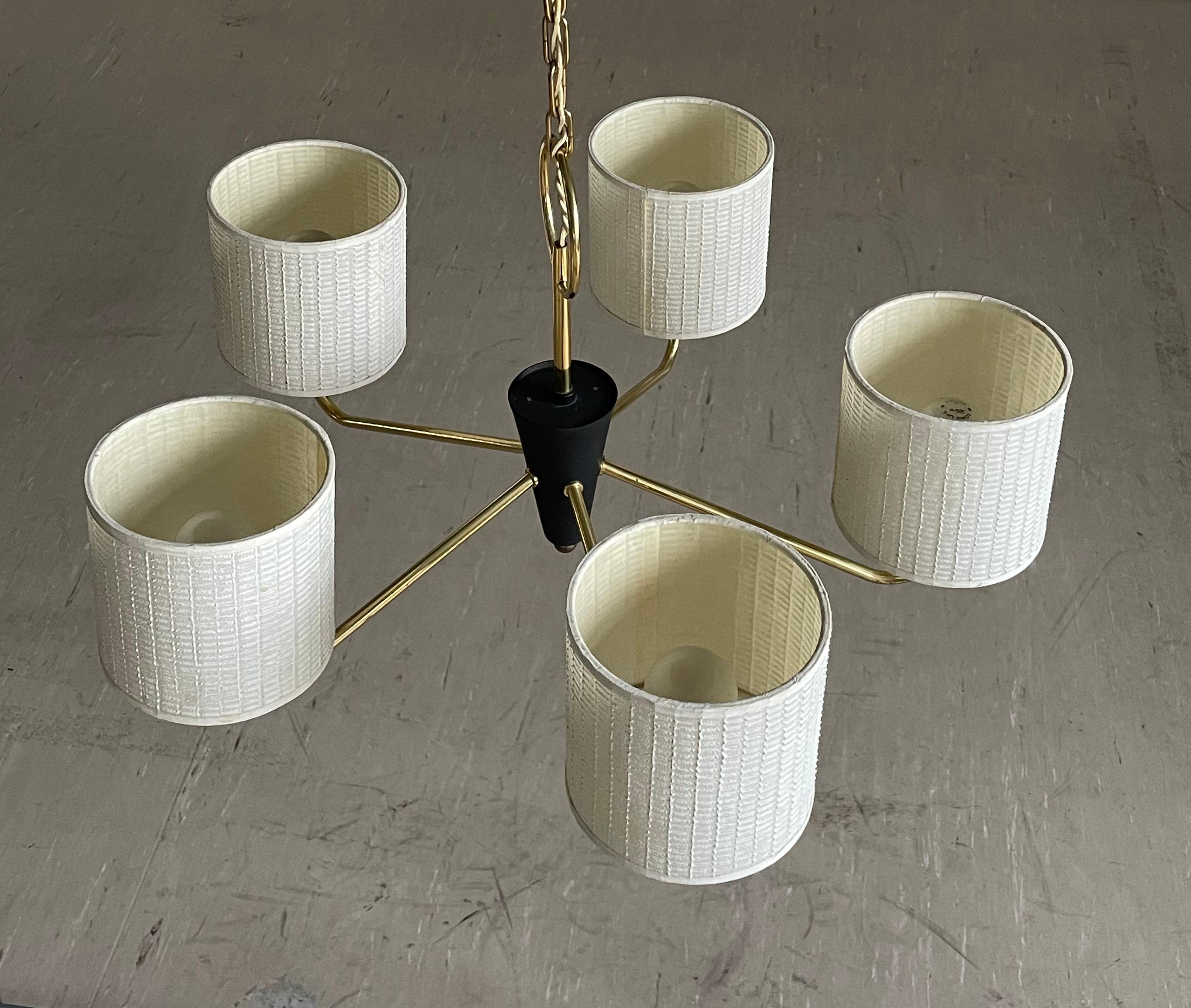 Lampada da soffitto in ottone e metallo degli anni '50 con cinque paralumi in tessuto su bracci in ottone.
Progettista: Sconosciuto
Produttore: Si ritiene che sia stato prodotto da Temde
Misure: Diametro ca. 50cm Altezza ca. 35 cm
Condit: Molto