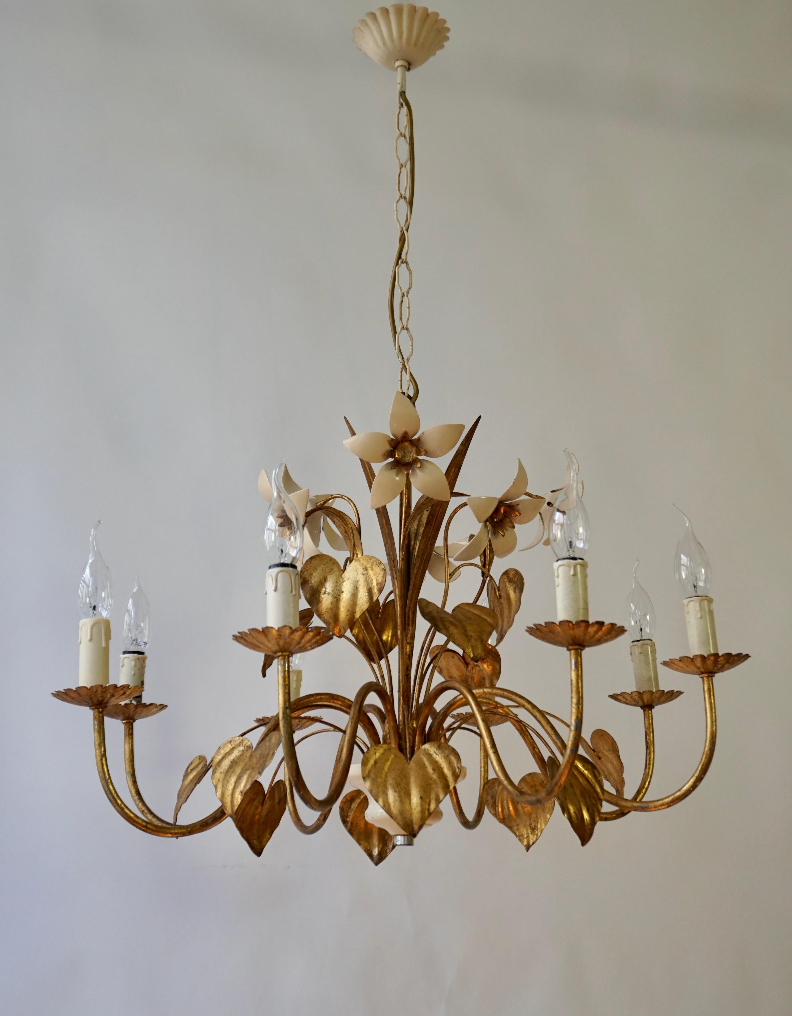 This beautiful gilt chandelier was designed and manufactured in Germany in the 1970s by Hans Kögl Leuchten. It features 5 lights and is made of antique gold-plated metal and off-white lacquered blossoms. Kögls designs were inspired by natural shapes