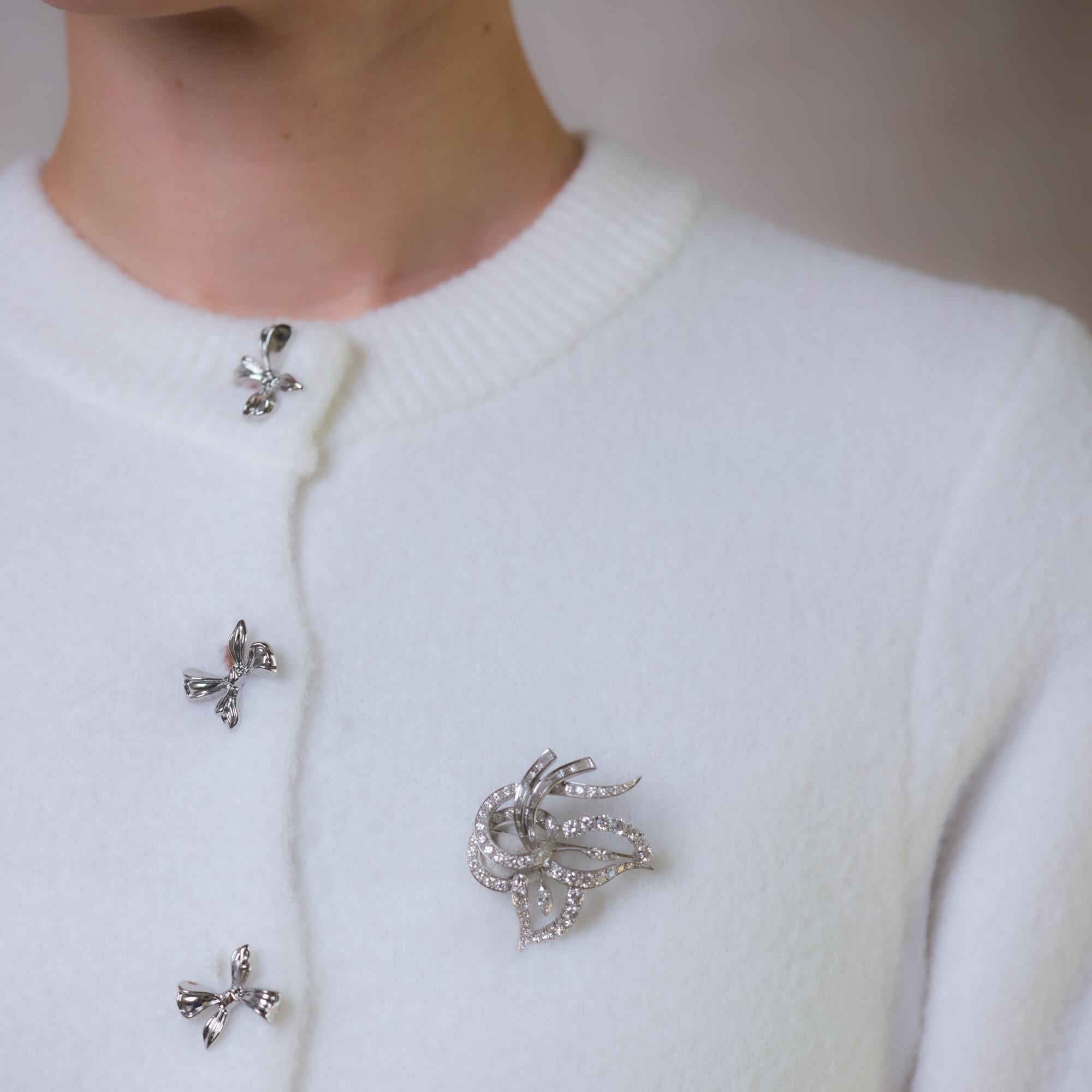 Questa squisita spilla di metà secolo in platino brilla con 80 diamanti rotondi taglio brillante, baguette e marquise per un totale di circa 5,50 carati, colore E, purezza VS. Un design sofisticato e senza tempo che mette in mostra un'eccezionale