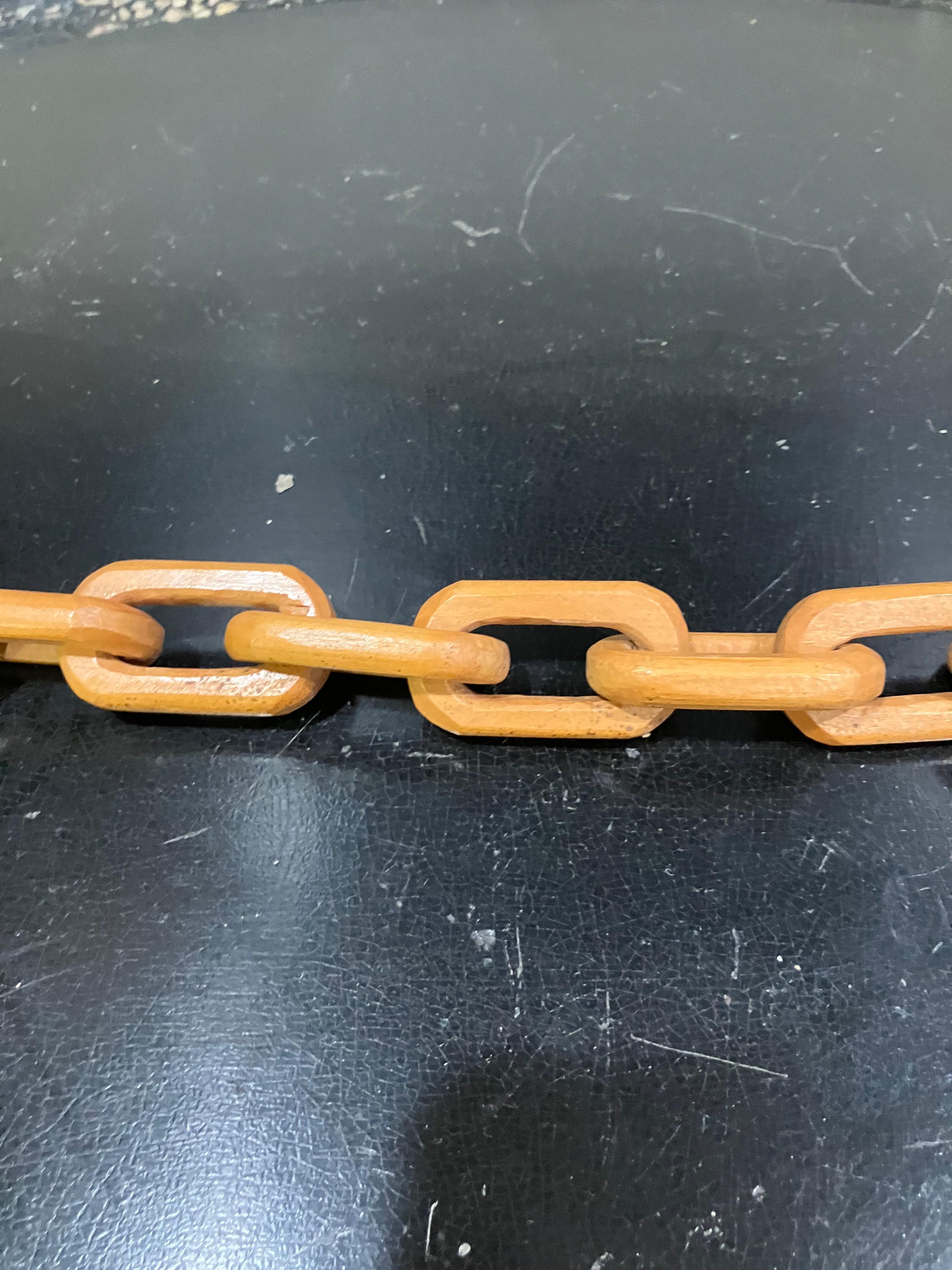 This 56-inch long chain is composed of interlocking wooden links, each carved from a single piece of wood. The continuous loop design reflects hand-crafted construction techniques. Made in the mid-20th century and discovered in Indiana, the piece is