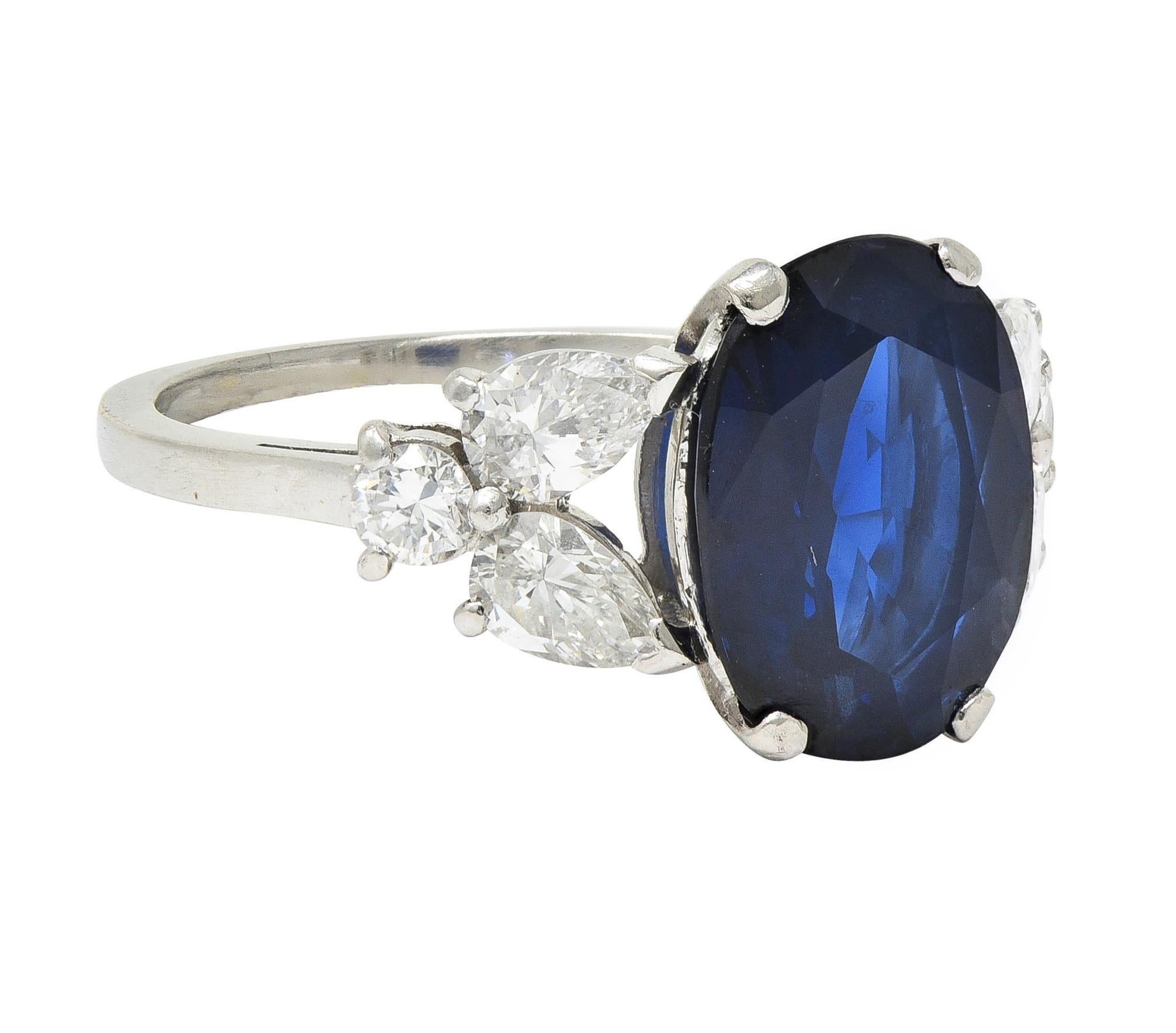 Centering an oval cut sapphire weighing approximately 4.20 carats - transparent dark blue in color
Prong set in basket and flanked by cathedral shoulders prong set with clustered diamonds
Pear and round brilliant cut - weighing approximately 1.40