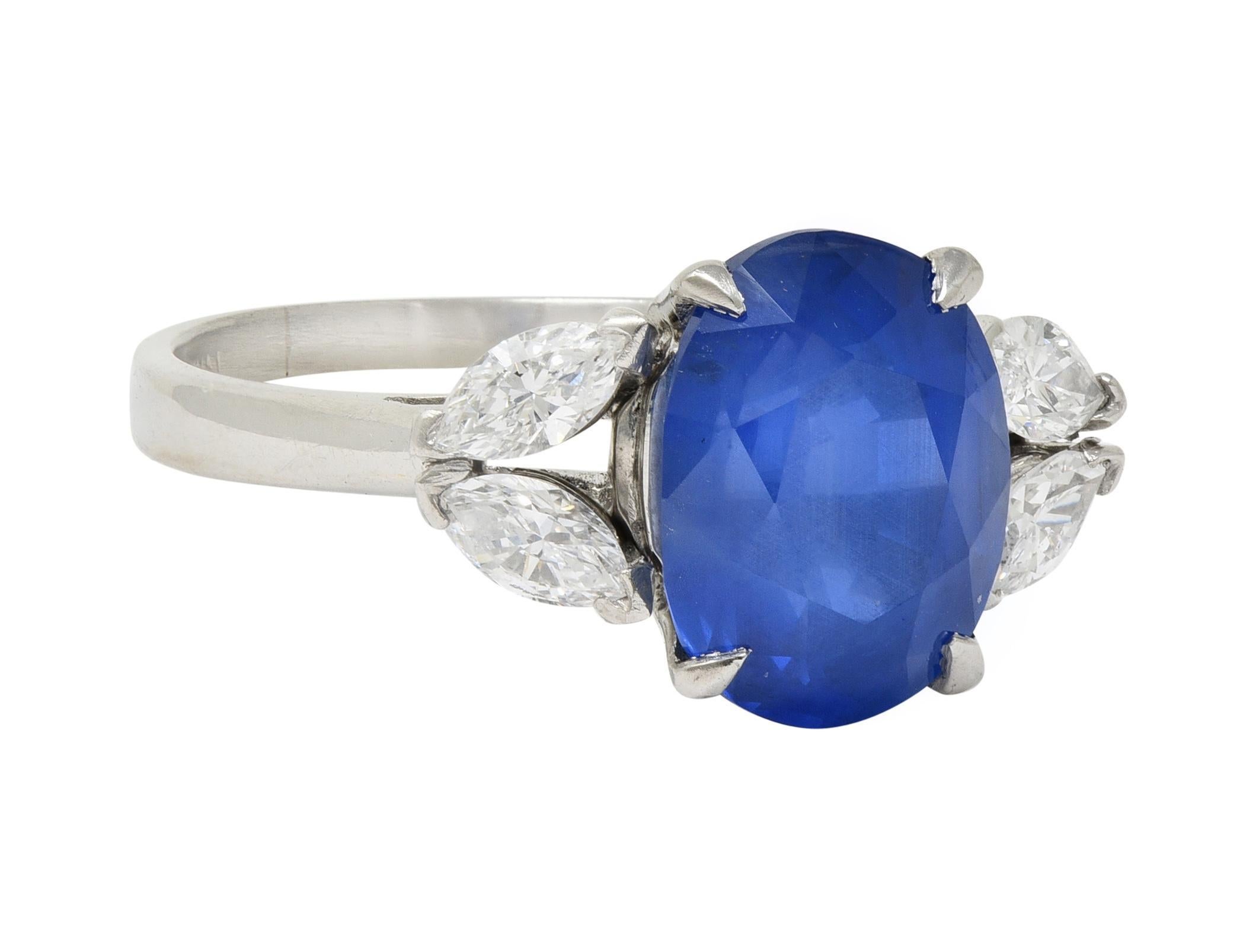 Centering an oval cut sapphire weighing 5.32 carats - transparent light to medium blue in color
Natural Burmese in origin with no indications of heat treatment - prong set in basket
Flanked by marquise cut diamonds clustered at cathedral