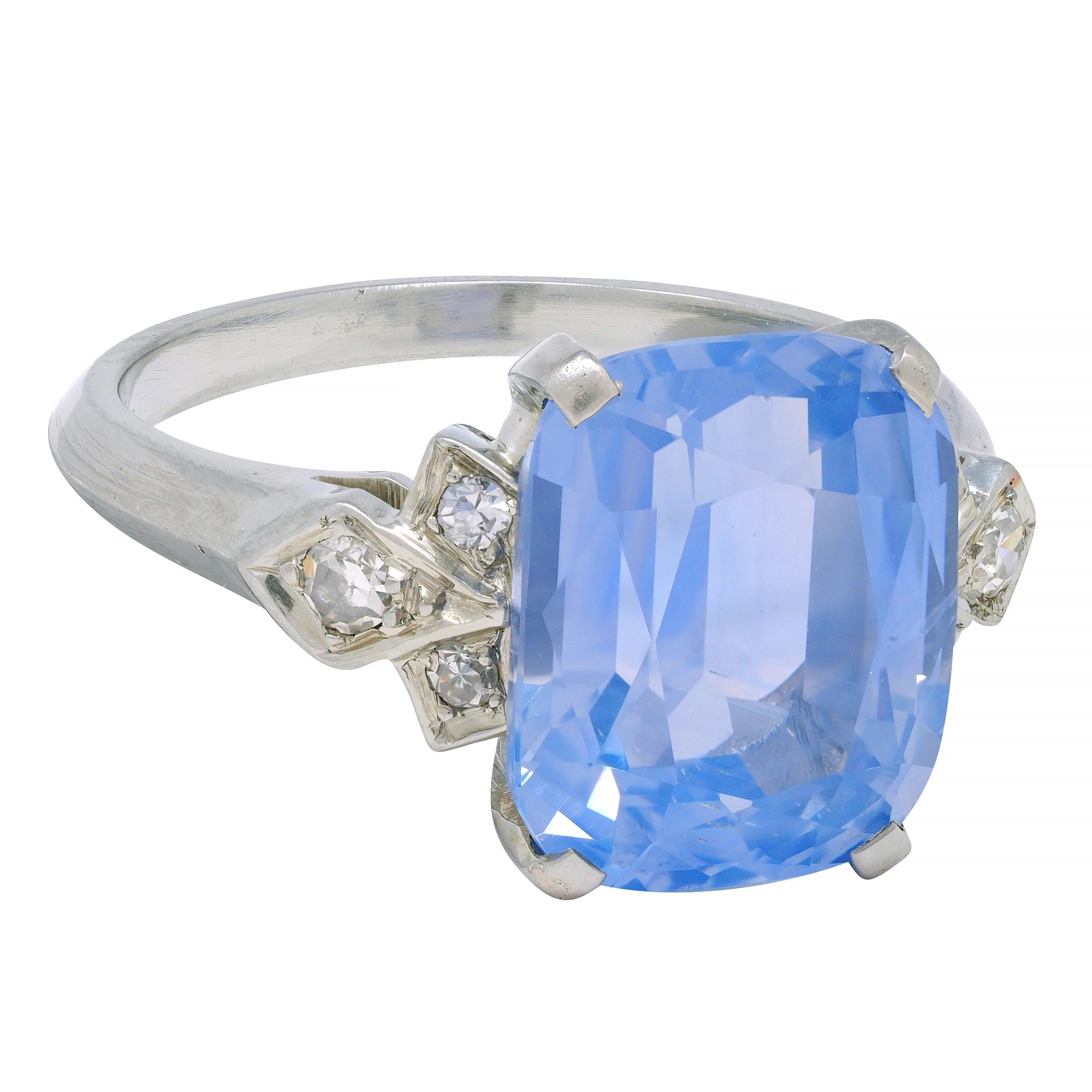 Centering a cushion cut sapphire weighing 6.44 carats - transparent light blue in color
Natural Ceylon in origin with no indications of heat treatment 
Prong set in basket and flanked by single cut diamonds 
Weighing approximately 0.16 carat total