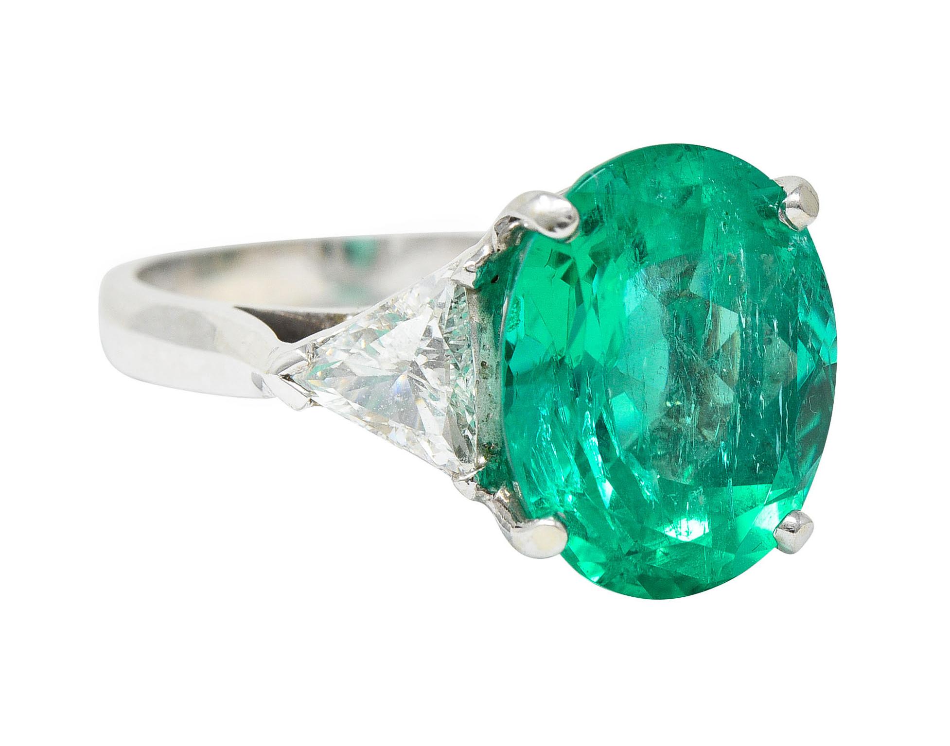 Featuring an oval brilliant cut emerald weighing approximately 6.00 carats

Colombian in origin with striking green color

Semi-transparent with natural inclusions and very minor clarity enhancement (F1)

Basket set and flanked by two trilliant cut