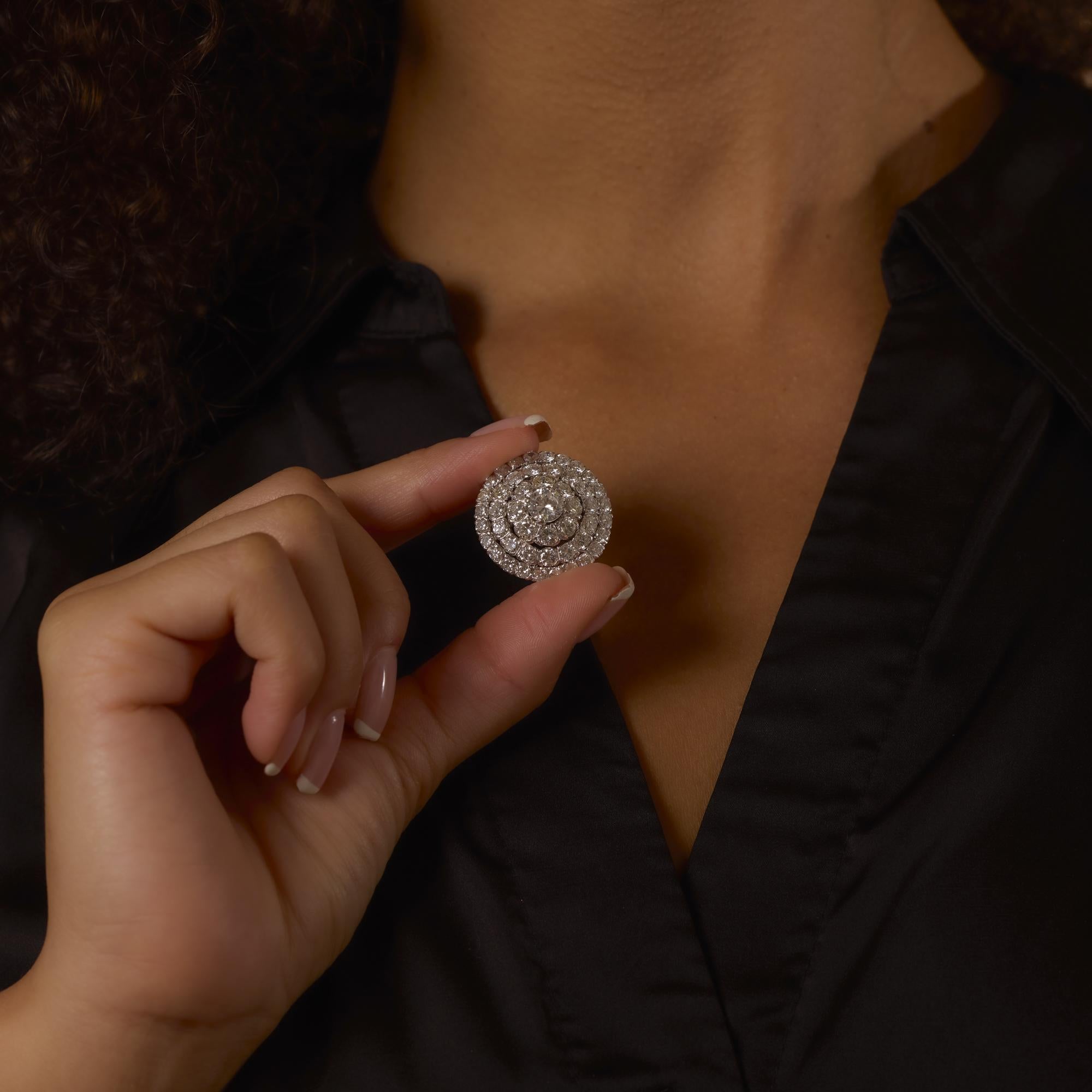 This elegant Mid Century pendant brooch dazzles with a 1.10 carat center diamond surrounded by nearly 6 carats of shimmering accent stones in luminous white gold.