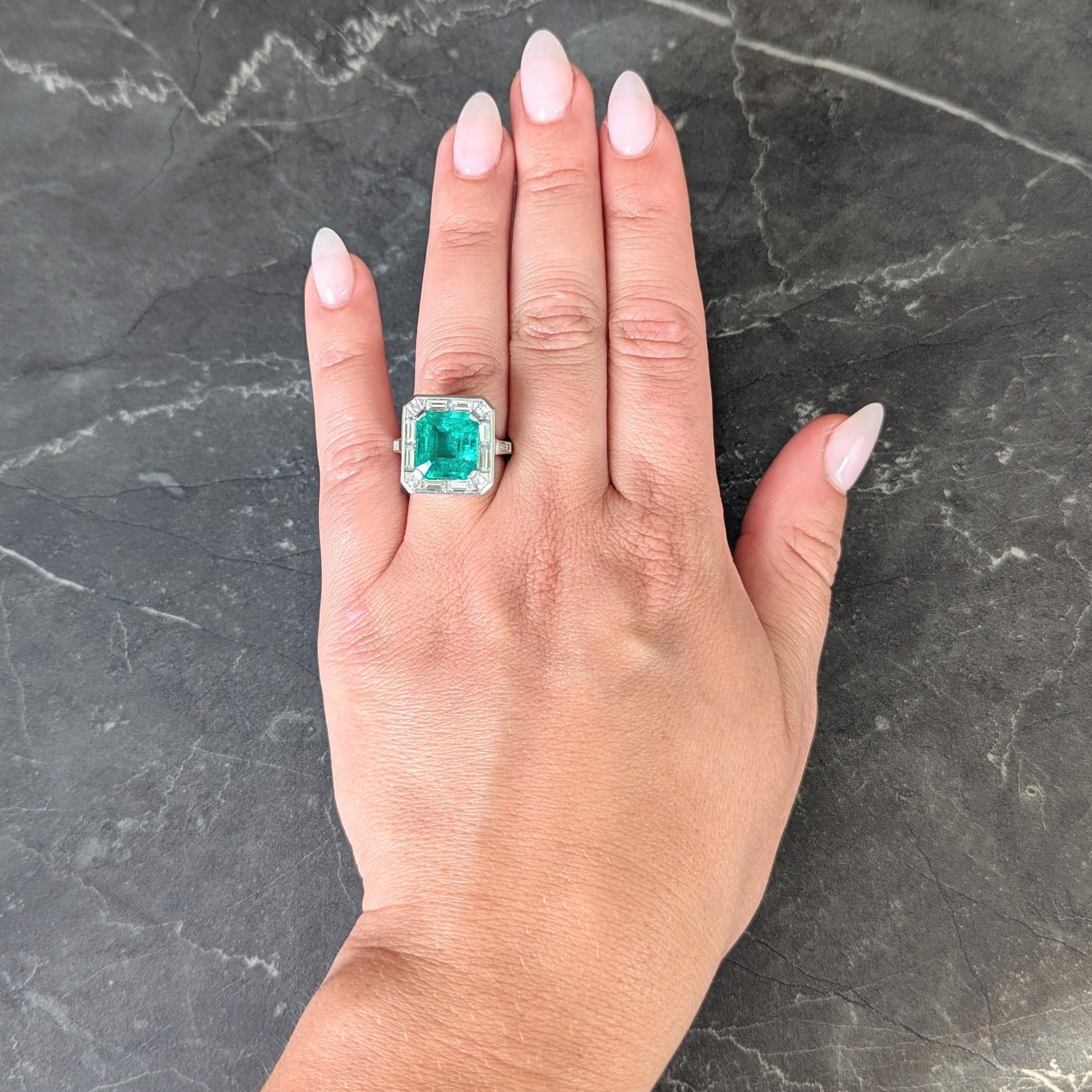Centering an emerald cut emerald weighing approximately 5.57 carats total - transparent medium green
Natural Colombian in origin and displaying minor clarity enhancement (F1) - prong set
Featuring a halo surround of channel set baguette and tapered