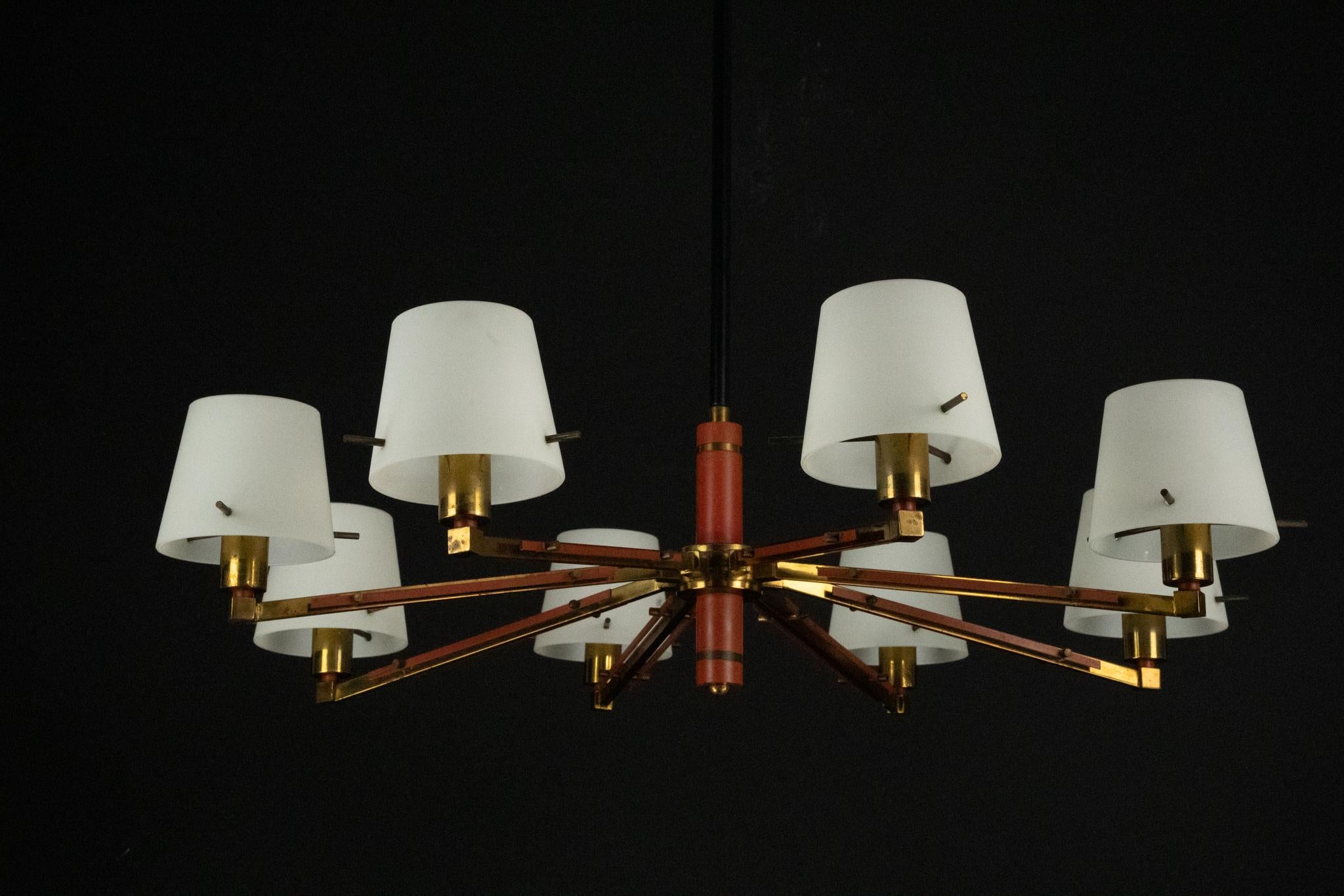 Un sorprendente lampadario Mid-Century di Stilnovo, risalente agli anni '50 e realizzato in Italia. Il pezzo presenta otto eleganti bracci in ottone, ognuno dei quali sostiene un elegante diffusore in vetro opalino che fornisce una luce morbida e