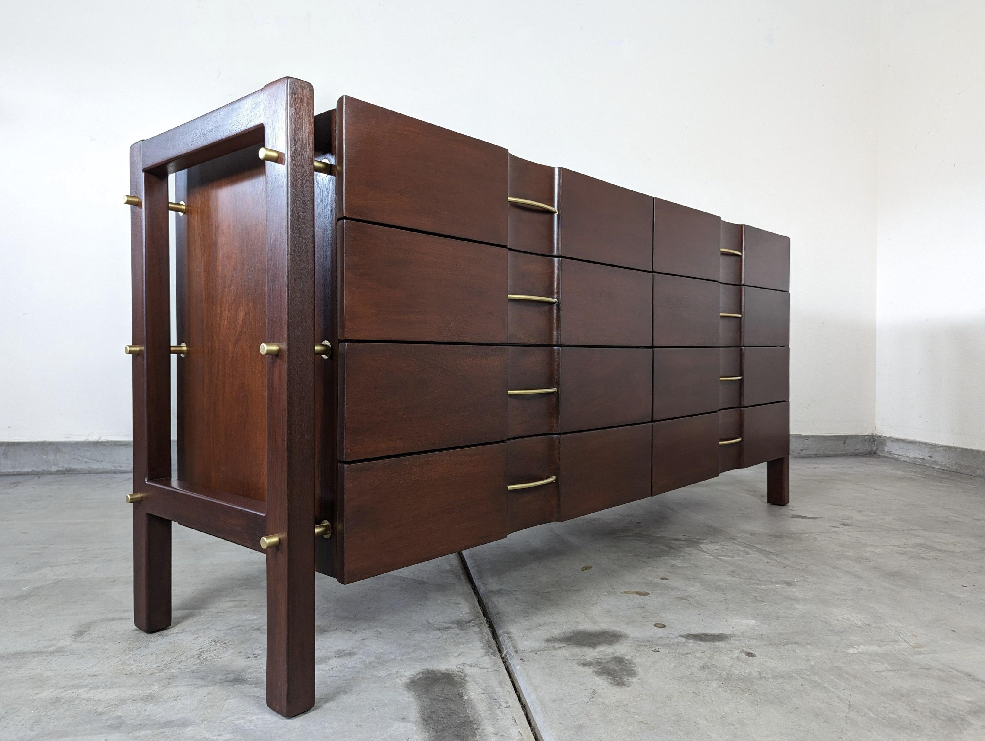 For sale is a spectacular mid-century dresser designed by the renowned Edmond J. Spence and manufactured by the esteemed Industria Mueblera of Mexico. This unique piece showcases the exceptional quality and timeless elegance of Spence's designs and