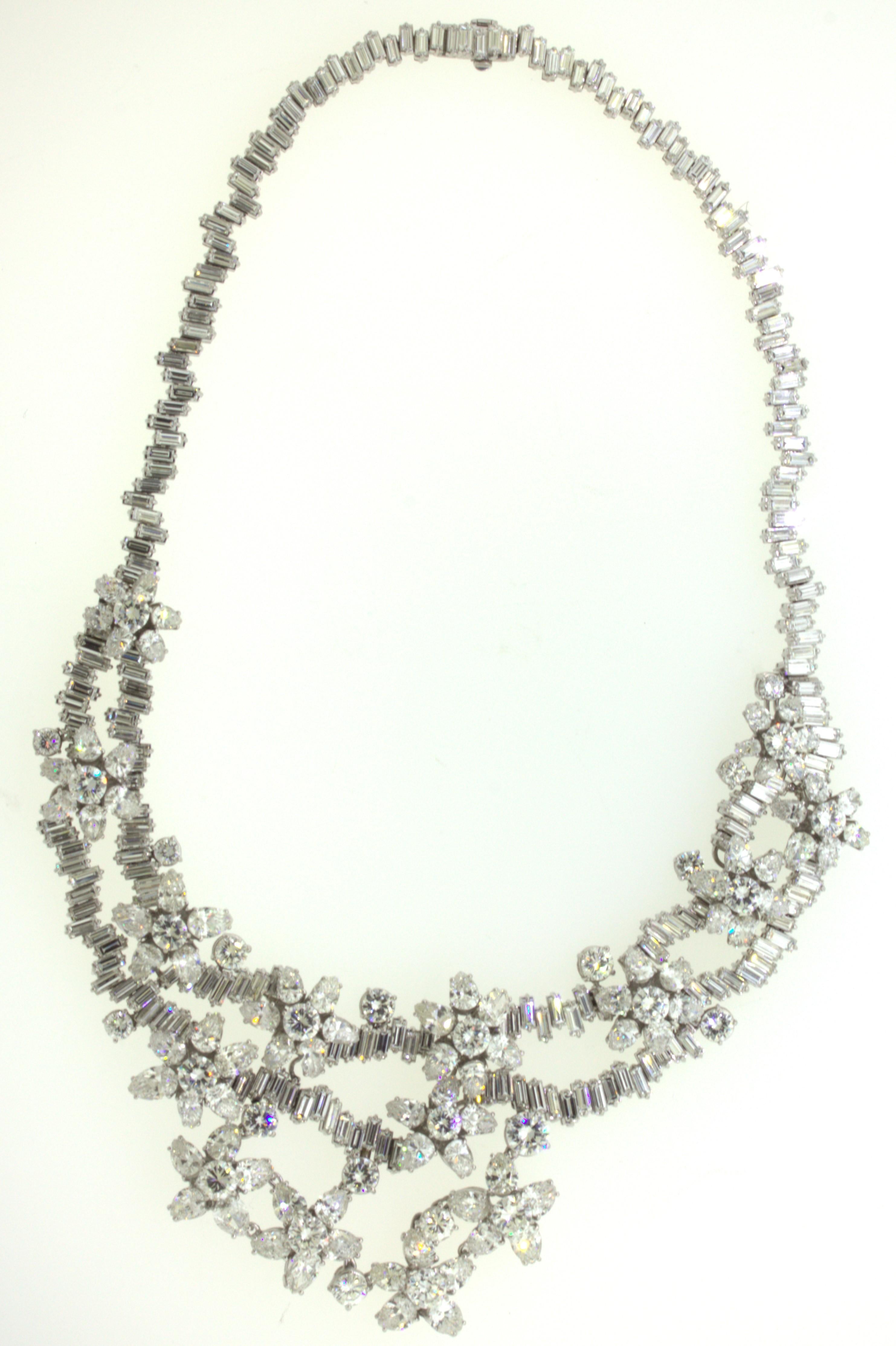A treasure from the 1950’s, this large and impressive diamond necklace is one of a kind. It features a total of 84 carats of large sizes round brilliant, baguette, and pear-shape diamonds set in clusters depicting flowers. The largest round diamond