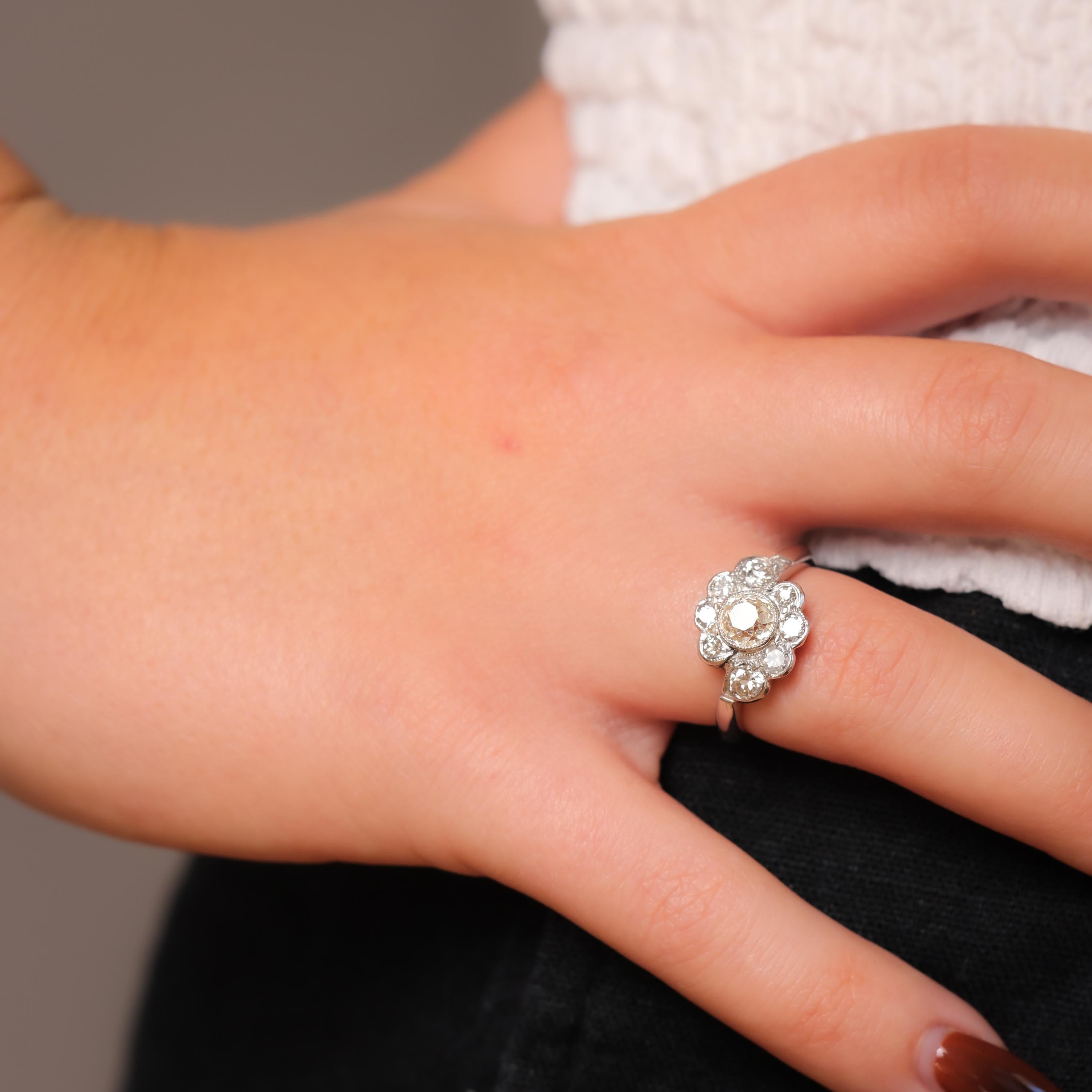 This Mid Century platinum flower cluster ring features a luminous 0.99-carat old mine-cut diamond surrounded by shimmering old European-cut diamonds. A timeless vintage masterpiece.

Center stone: Old mine cut diamond 
Weight: .99 carat
Color: Light