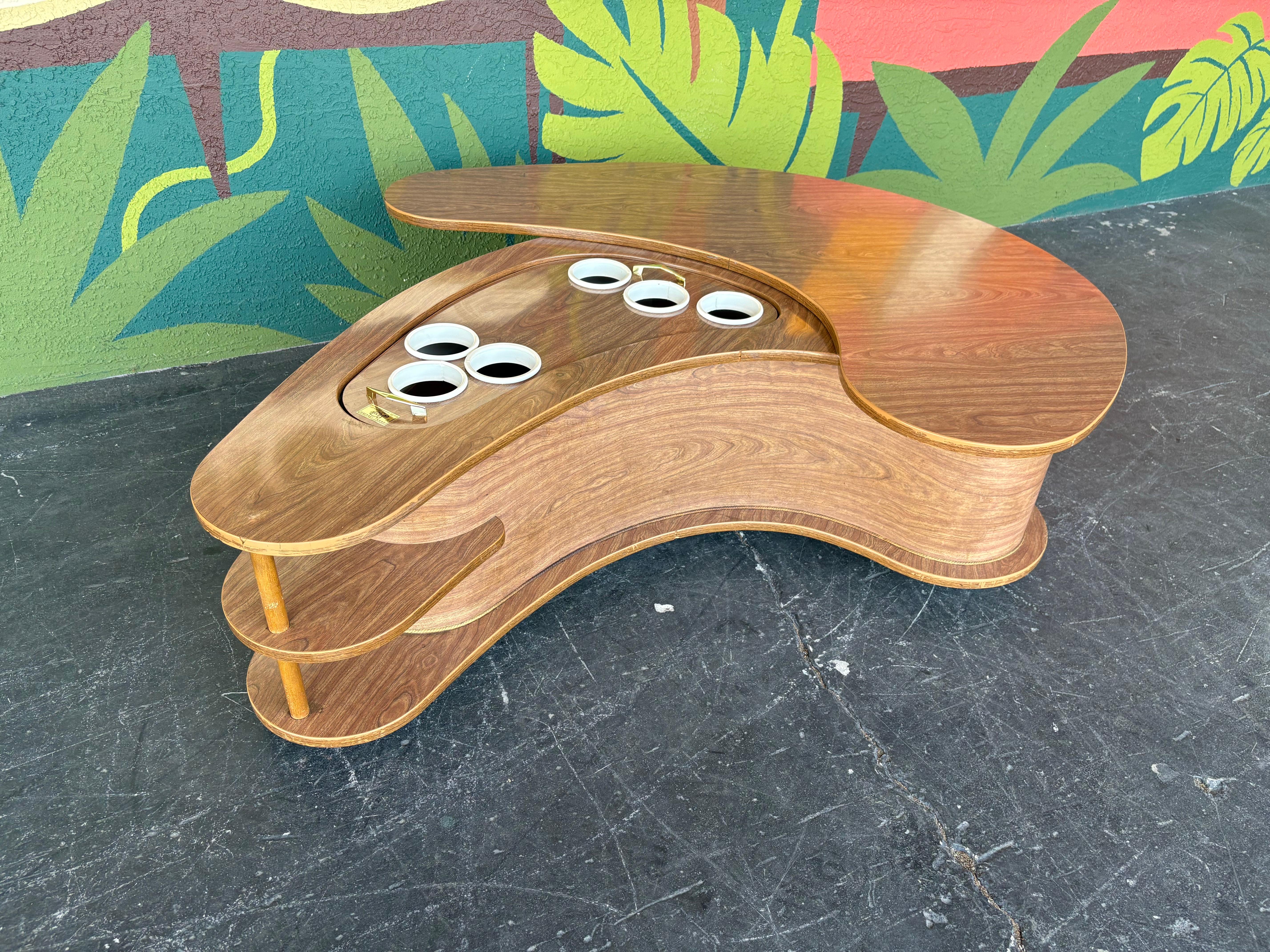 Iconic design in this swivel boomerang grand server coffee table. It’s on casters for ease of movement/positioning, the swivel top rotates smoothly, and the drop server also functions perfectly. Durable laminate that can handle plenty use and is