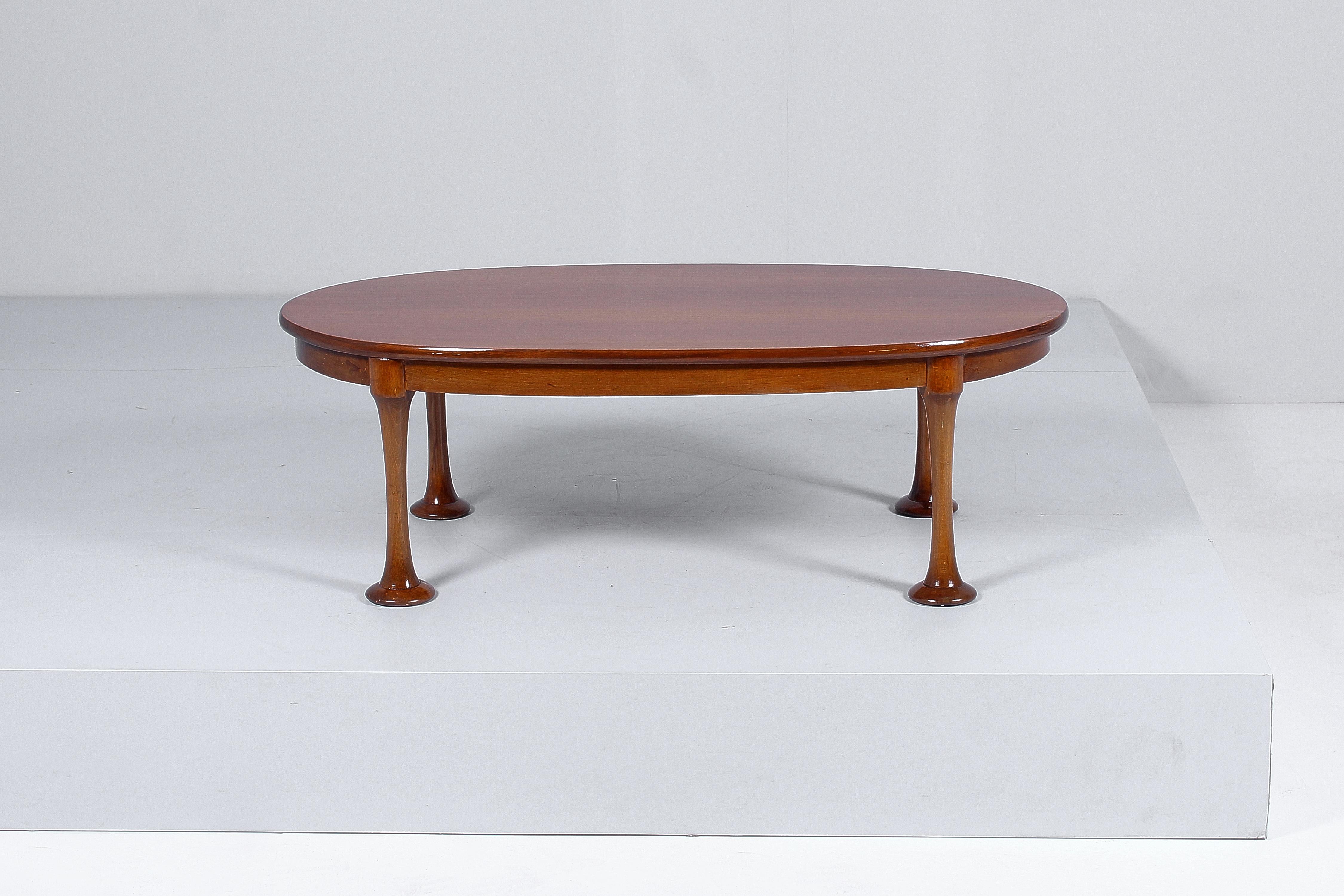 Particular and original restored oval coffee table with four cylindrical legs with flared feet. In the style of Angelo Mangiarotti, Italian production from the 60s.