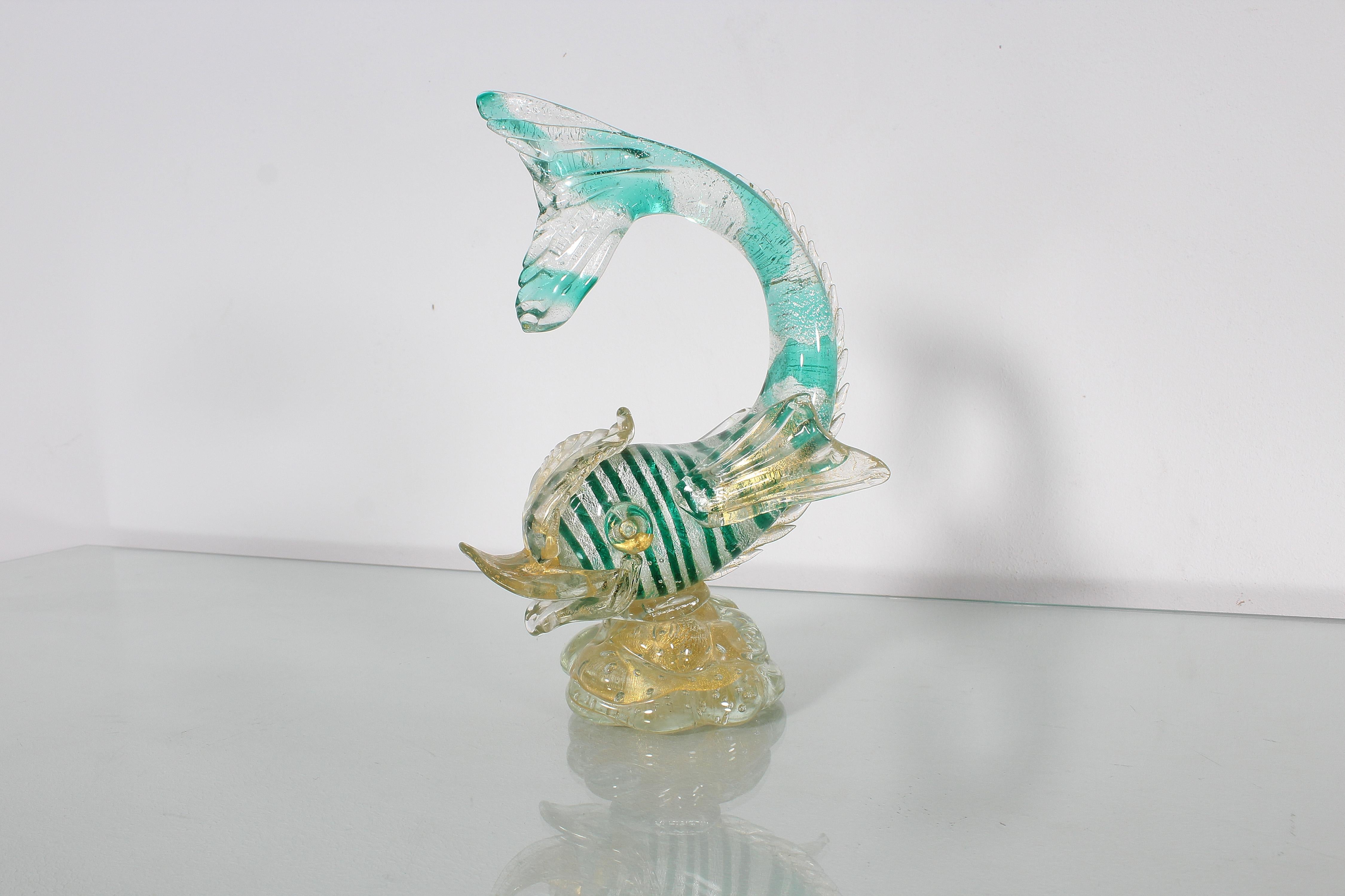 Delicious Murano artistic glass miniature depicting a moving fish. Body in filigree glass with alternating white and green bands, tending towards light blue on the tail. Transparent glass applications with gold leaf inclusions. Attributed to