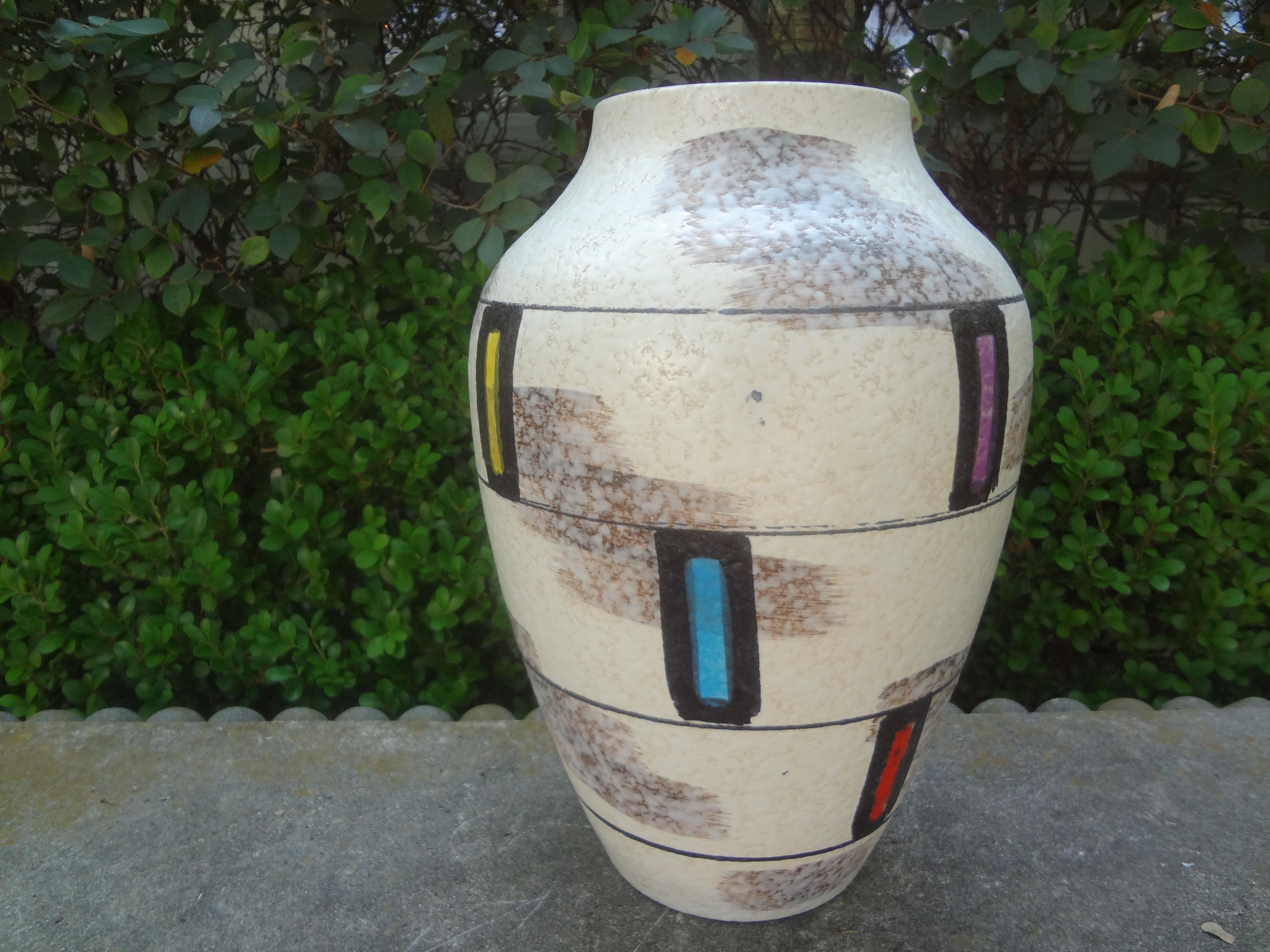 Mid-century Abstract Glazed Pottery Vase From West Germany.
This lovely vase is executed in an interesting geometric abstract design in purple, yellow, red and turquoise on a cream colored background.
Just one in our large collection offered on