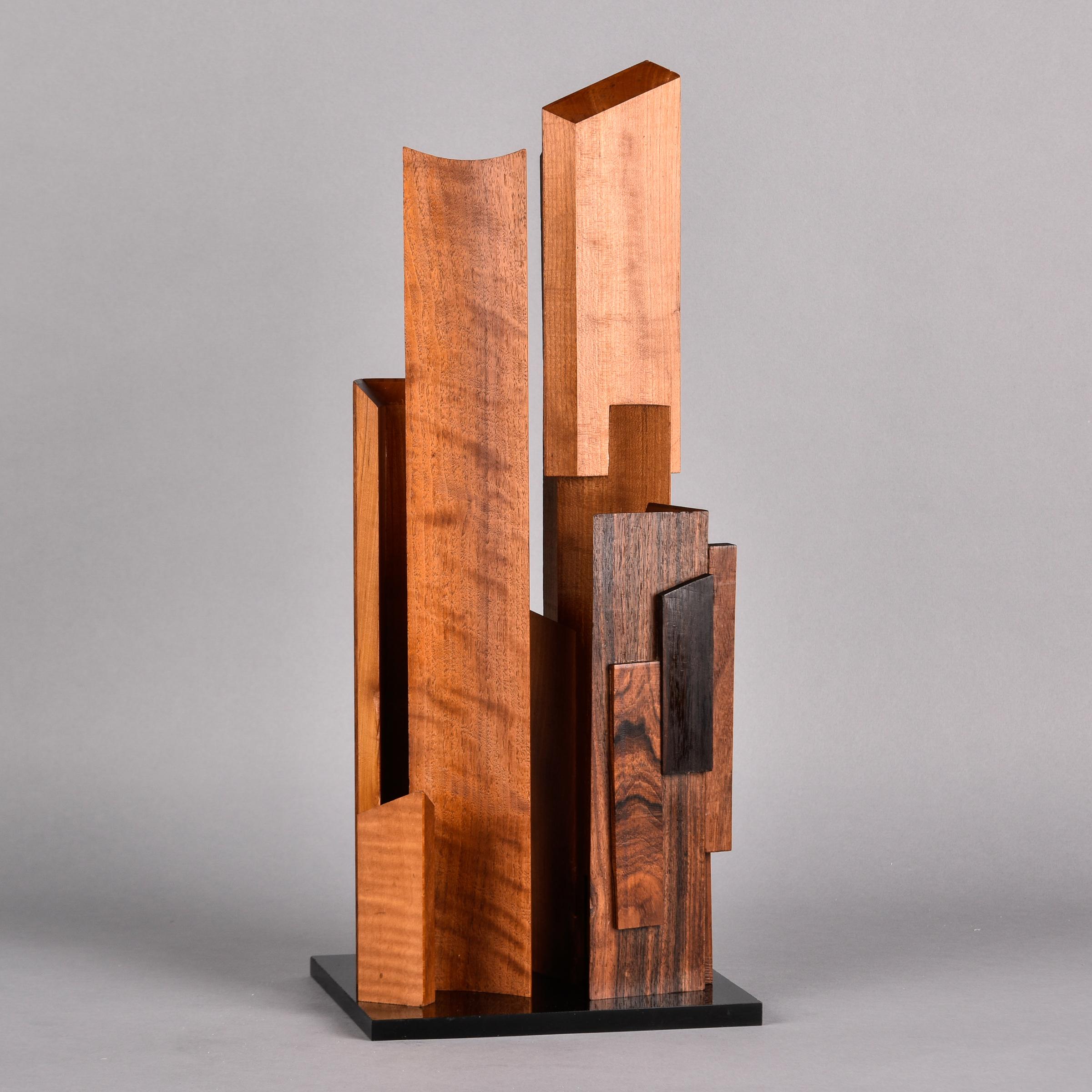 Found in the US, this abstract wood sculpture is attributed to Vermont artist Gibb Taylor and dates from the late 1960s. This table top sculpture is just under two feet tall and consists of upright polished wood pieces of walnut and rosewood and
