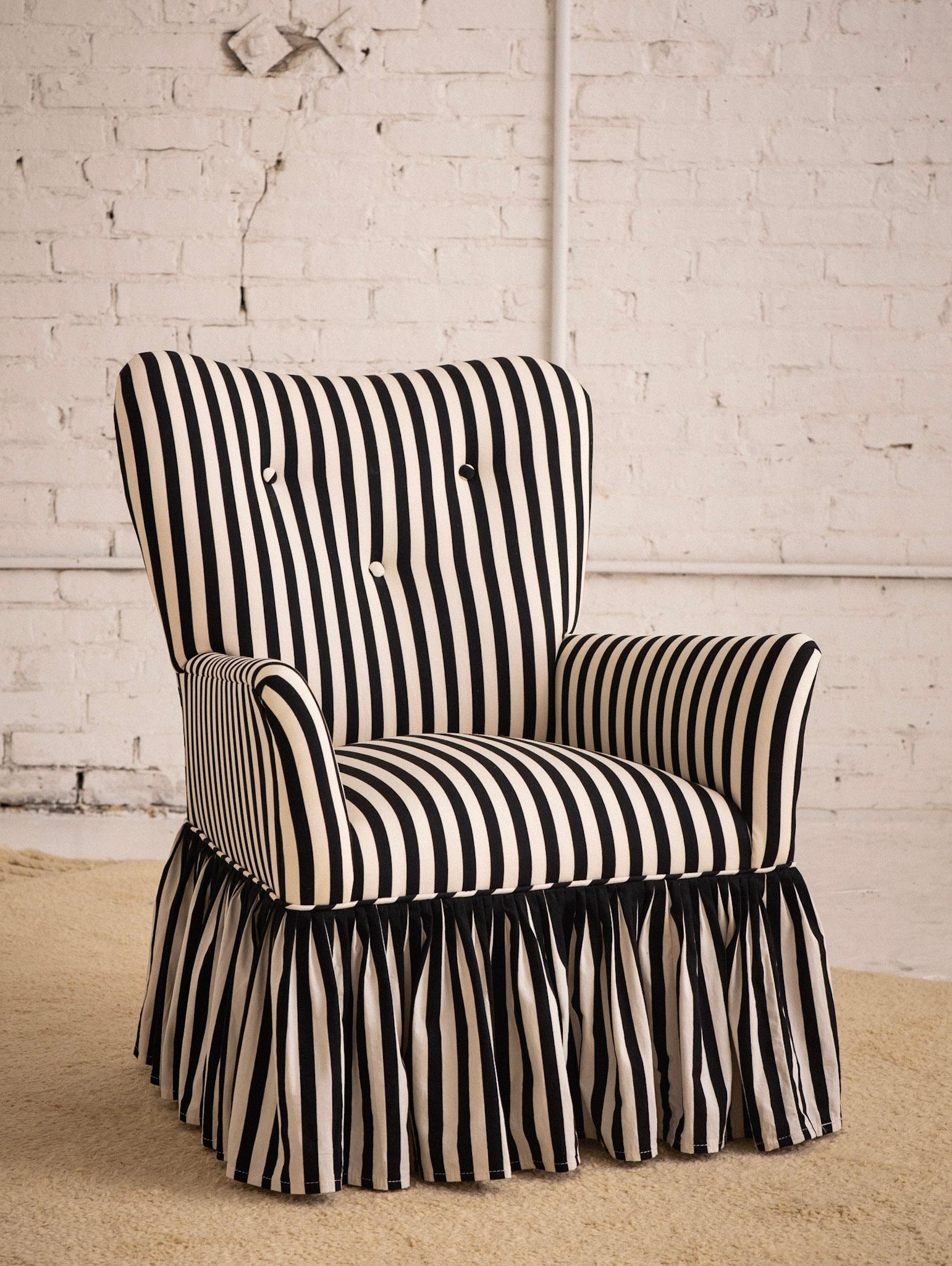 A Mid Century side chair with ruffled skirt. Newly reupholstered in a vintage 1960’s dead stock black and white striped cotton fabric. Heart shaped back silhouette.