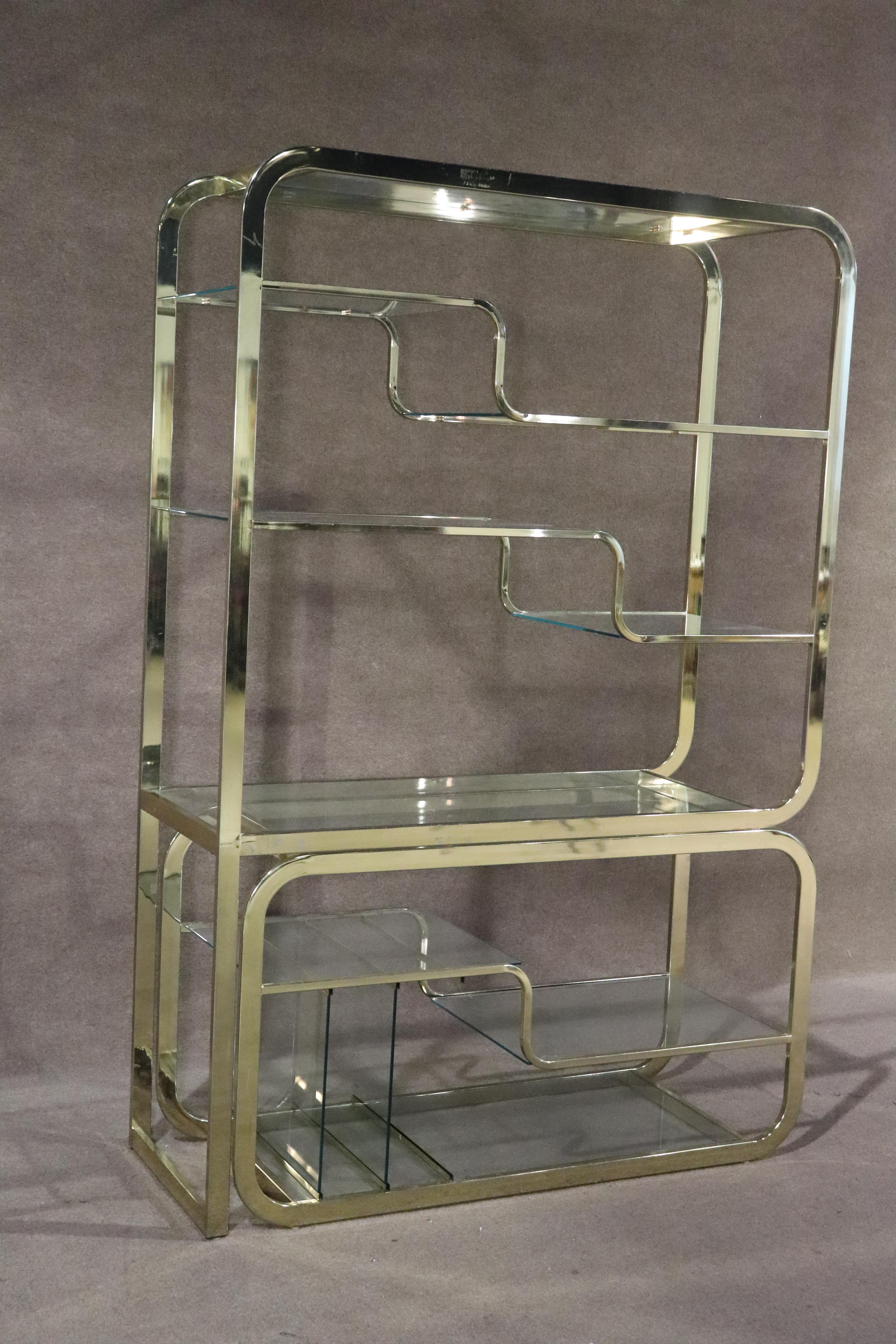 Vintage polished brass etagere unit with movable base. This makes a great see through room divider, with bookcase on top and dry bar storage on the bottom.
Please confirm location NY or NJ