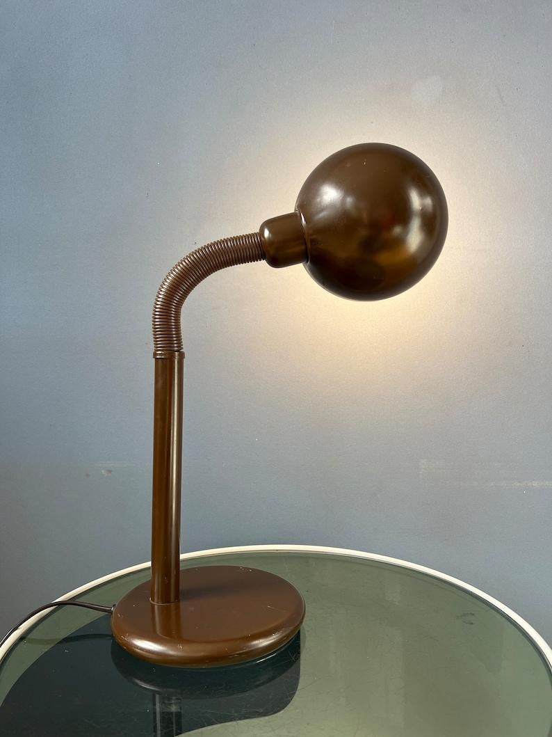 Mid century brown space age desk lamp with flexible arm. The arm and shade can be positioned in any way desirable. The lamp is made out of metal and plastic. The lamp requires one E27/26 (standard) lightbulb and currently has an EU plug.

Additional