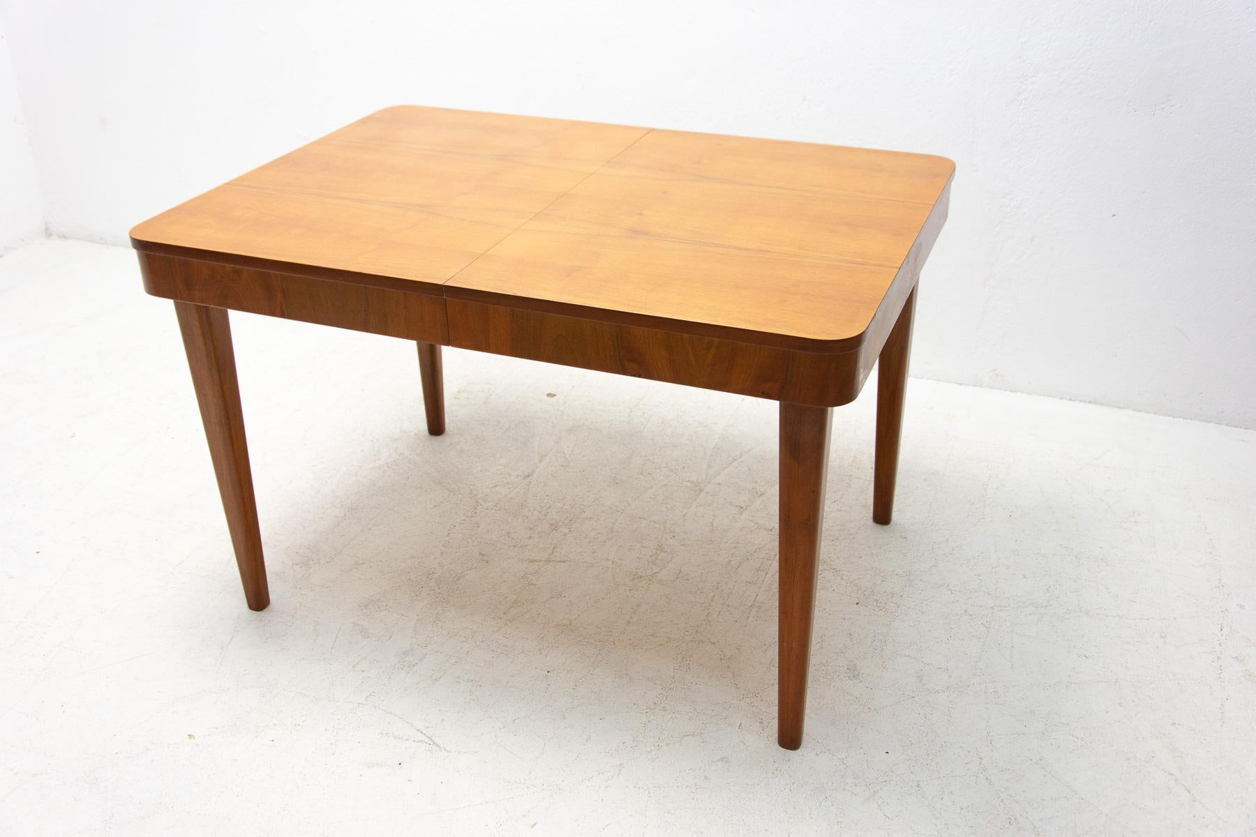 This adjustable dining table was designed and made in the 1950s in the former Czechoslovakia. It was designed by Jindrich Halabala for ÚP Závody Brno. The material is a combination of solid wood and walnut veneer. The table is in good Vintage