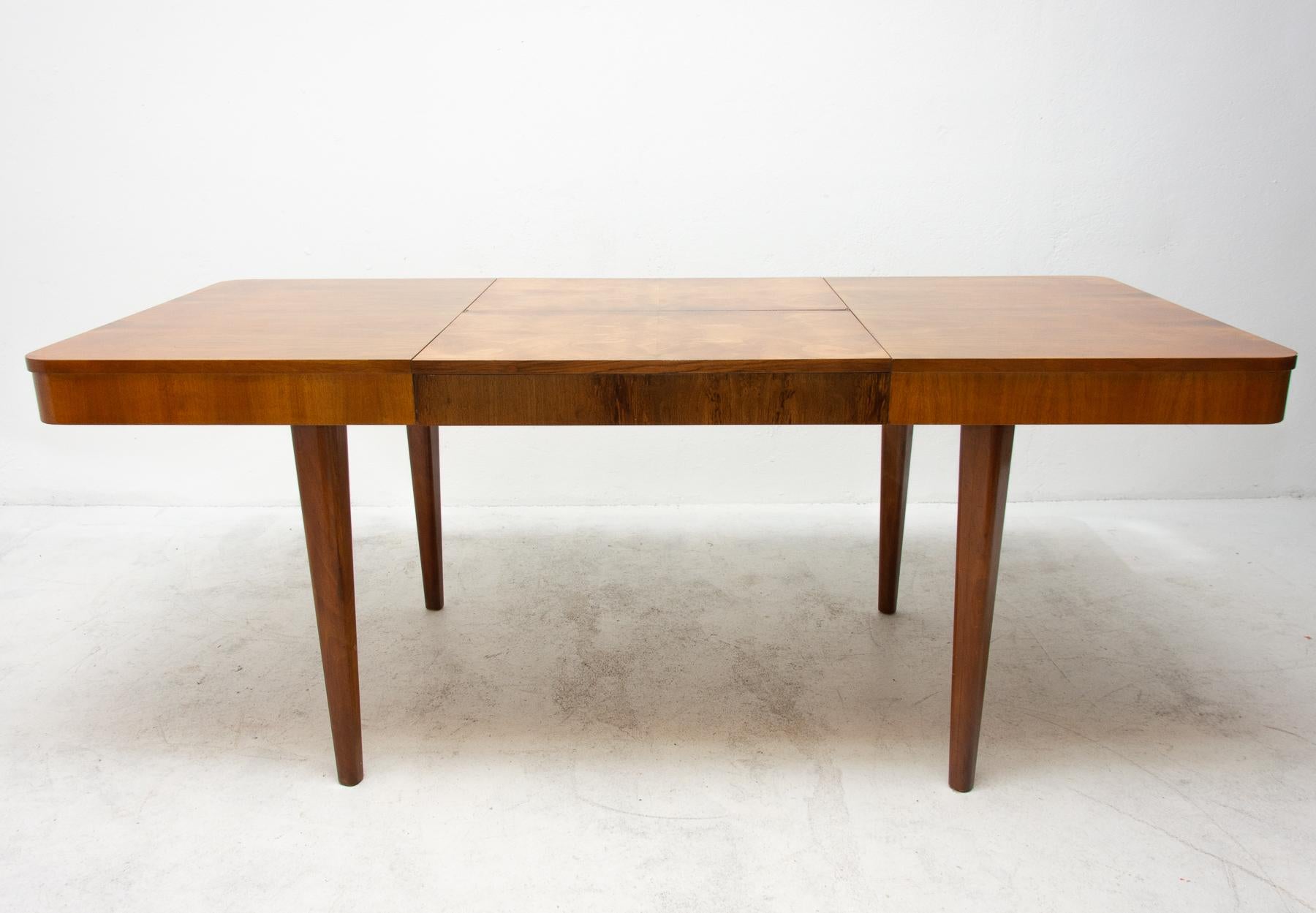 This adjustable dining table was designed and made in the 1950s in the former Czechoslovakia. It was designed by Jindrich Halabala for ÚP Závody Brno. The material is a combination of solid wood and walnut veneer. The table is in excellent Vintage