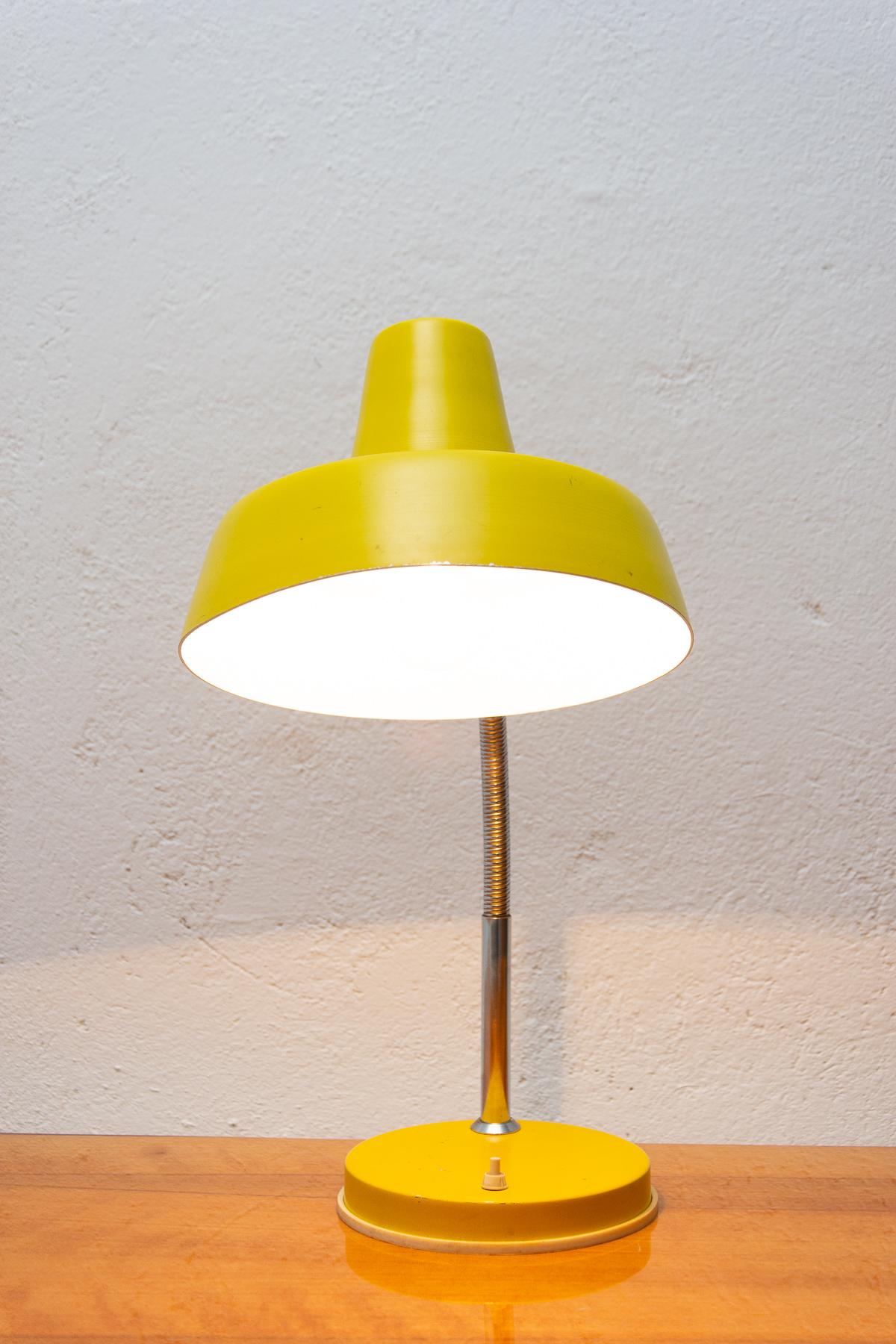 This lamp was made in the 1950s in the Central Europe.

It has a plastic shade; chrome adjustable gooseneck supports on yellow plastic base with a push-button switch. It has a new wiring.

Works on one bulb E27, European plug. In very good