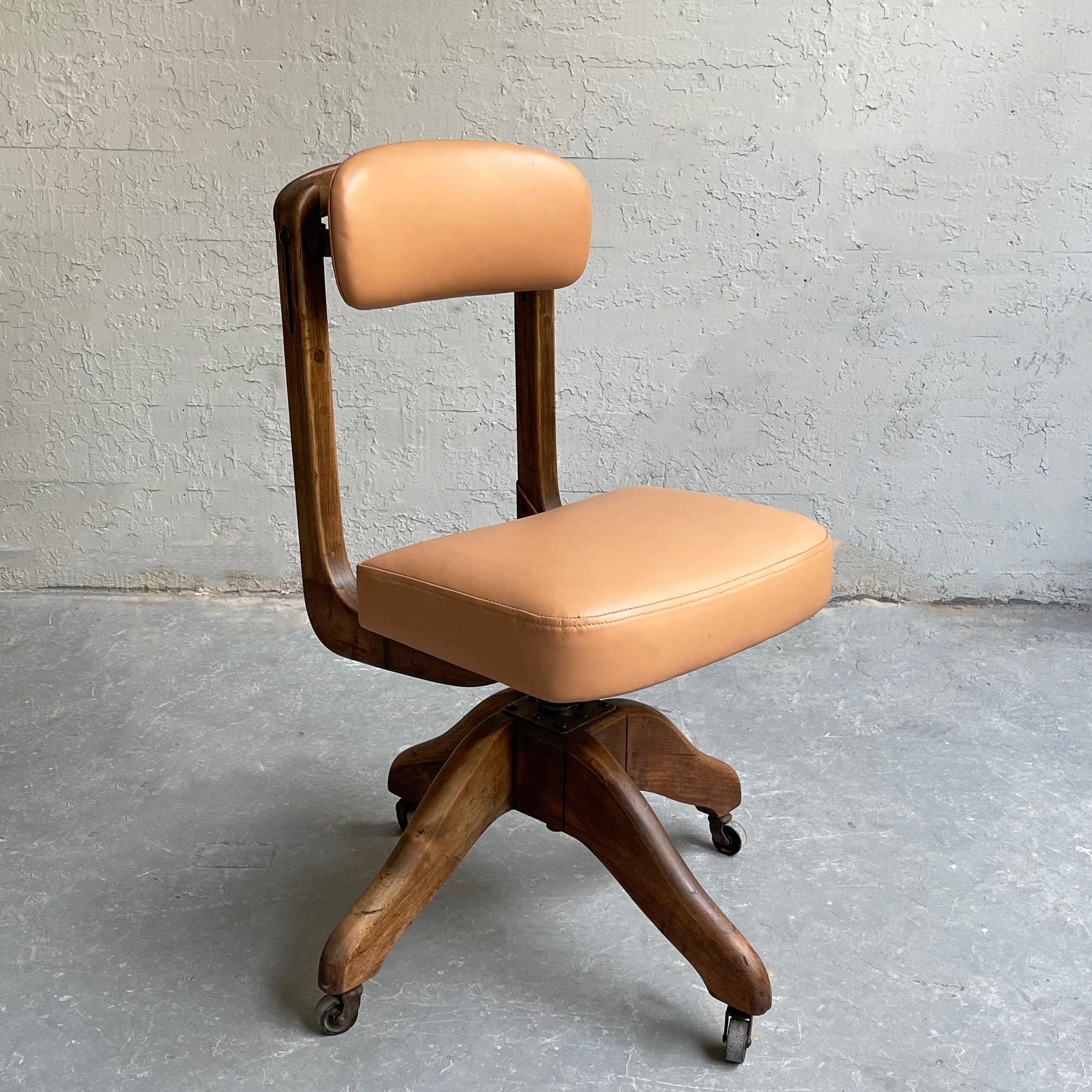 Industrial, midcentury, office desk chair by DoMore Chair Company features a height adjustable 16 - 19 inch, rolling, swivel oak frame with newly upholstered blush pink leather seat and back. The back height is also adjustable.