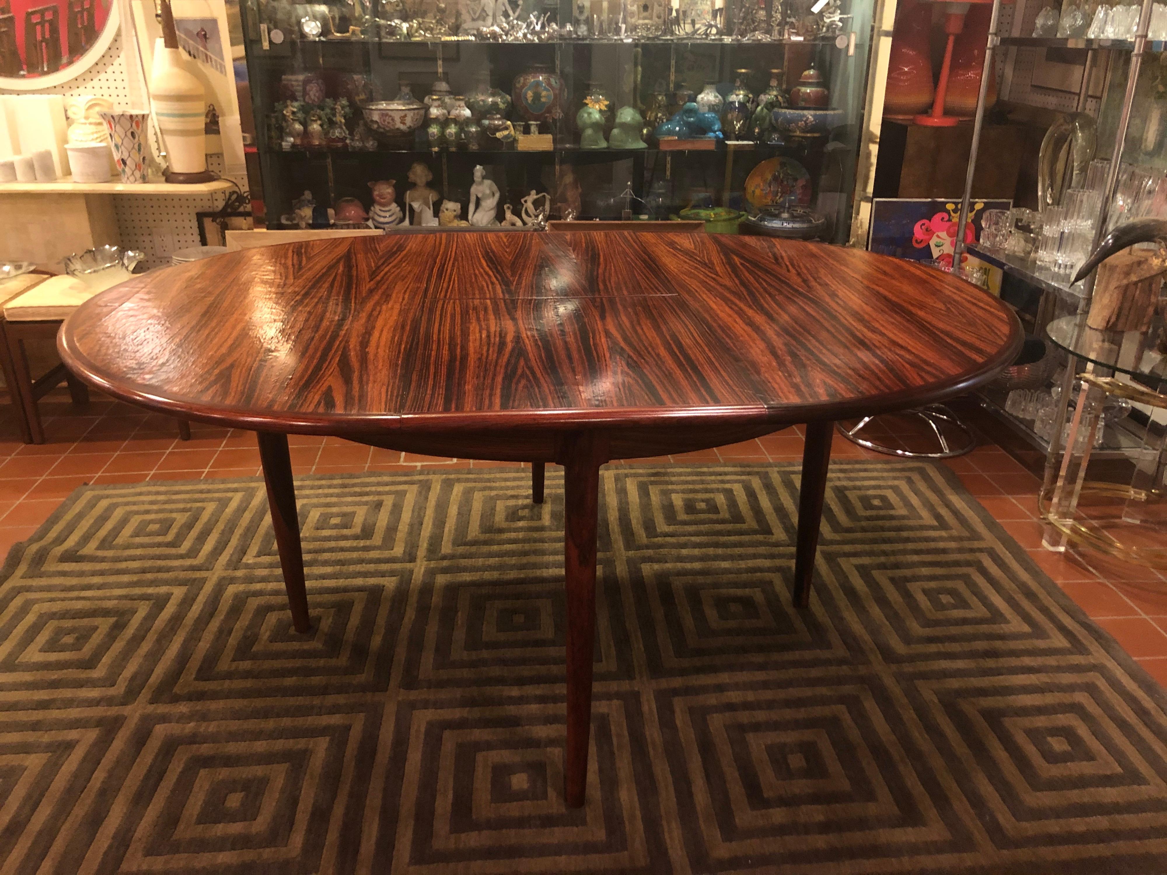 Mid Century adjustable rosewood dining table. Inner leaf folds down into the table to make it round if you need it smaller. Set of 6 teak dining chairs are also available in a separate listing. Labeled Danish Control furniture makers. With the leaf