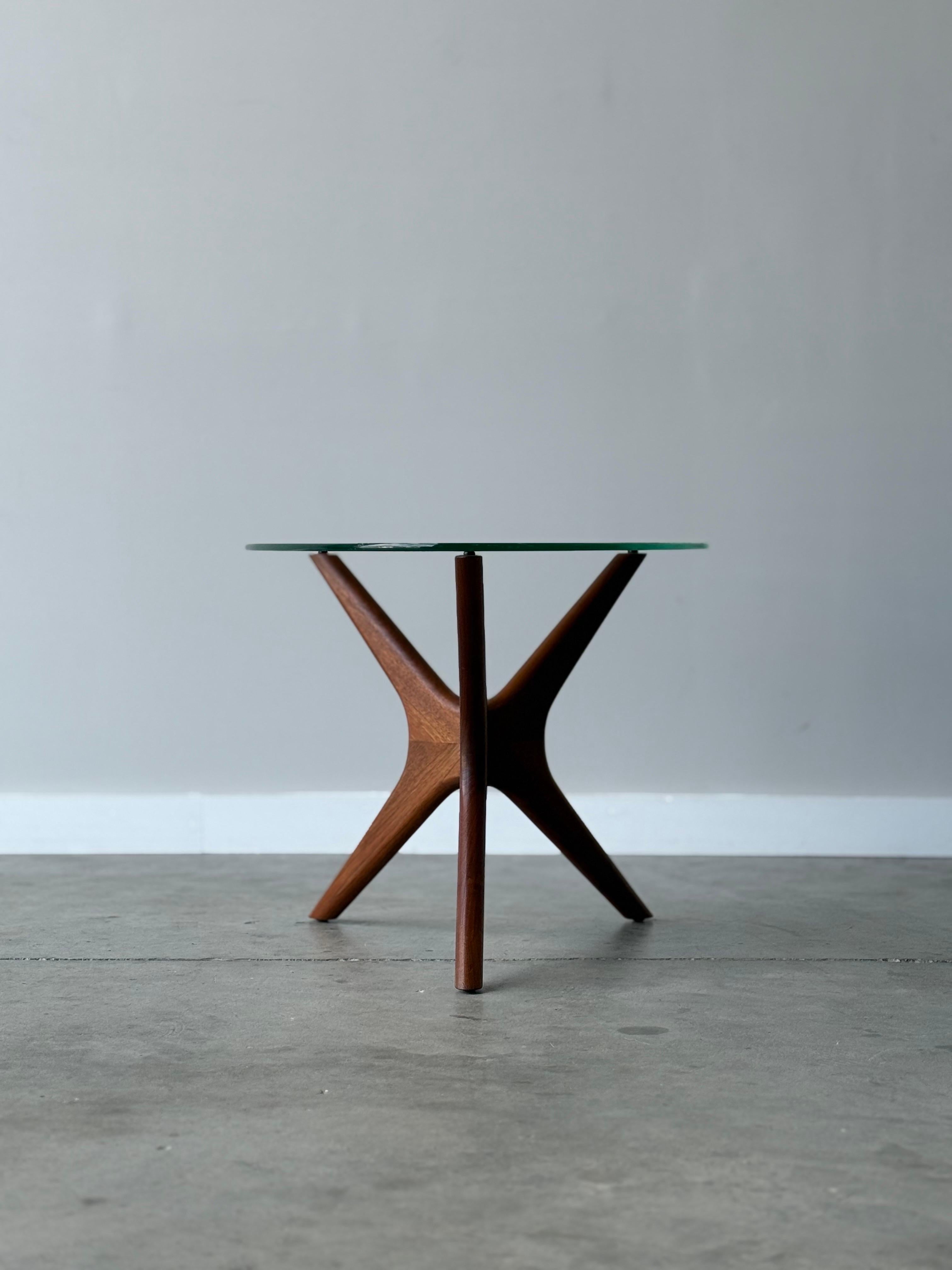 Mid-century “Jacks” side table designed by Adrian Pearsall, made circa 1960s. This particular piece features a sleek, triangular or “guitar pick” glass top that rests gracefully on a sculptural walnut wooden base, warm in tone.

The wooden base is