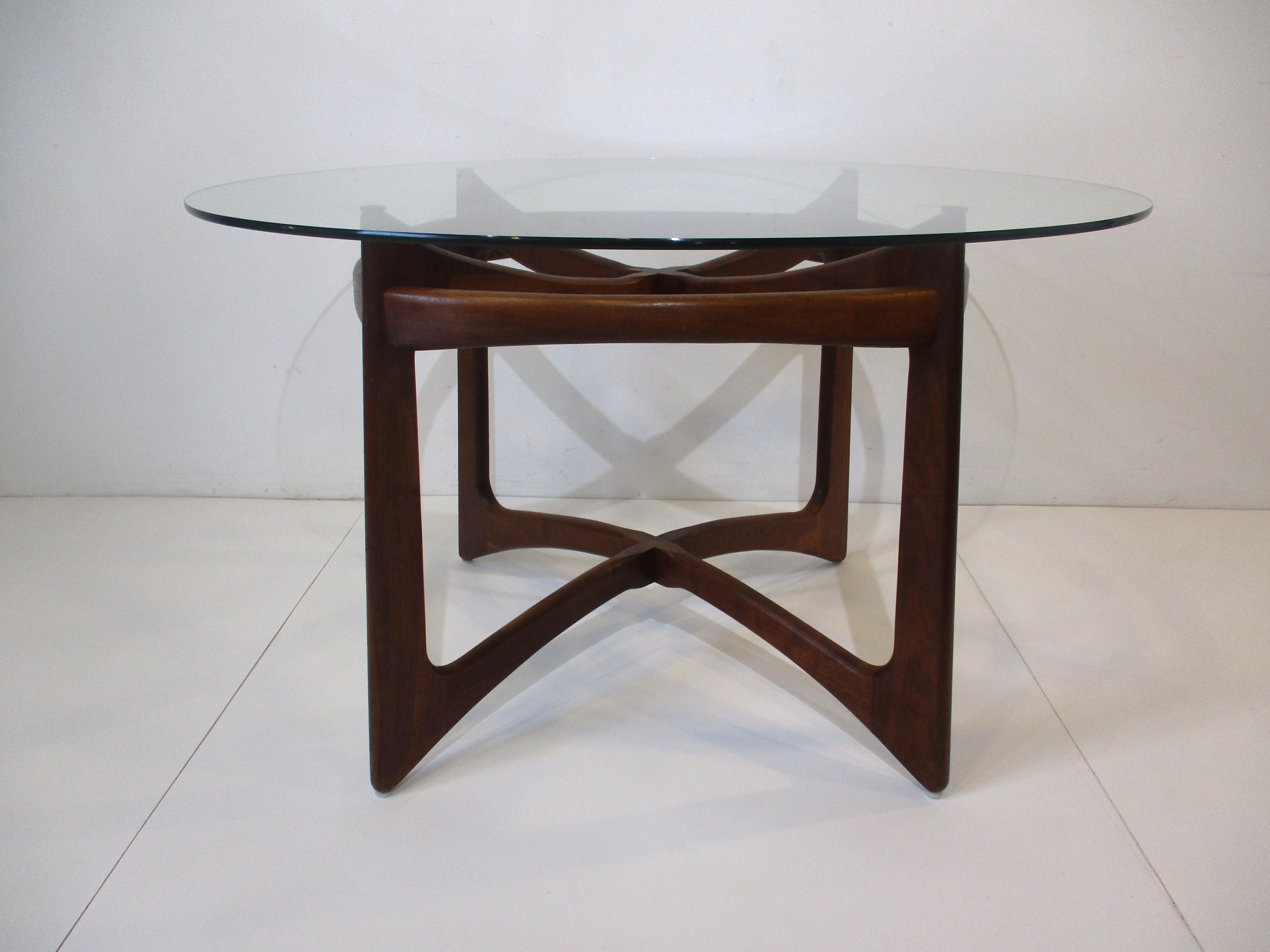 A sculptural solid walnut based ribbon styled dining table with round glass top designed by Adrian Pearsall . A very well organically crafted piece manufactured by Craft Associates showing the beauty of the natural wood in the manner of George