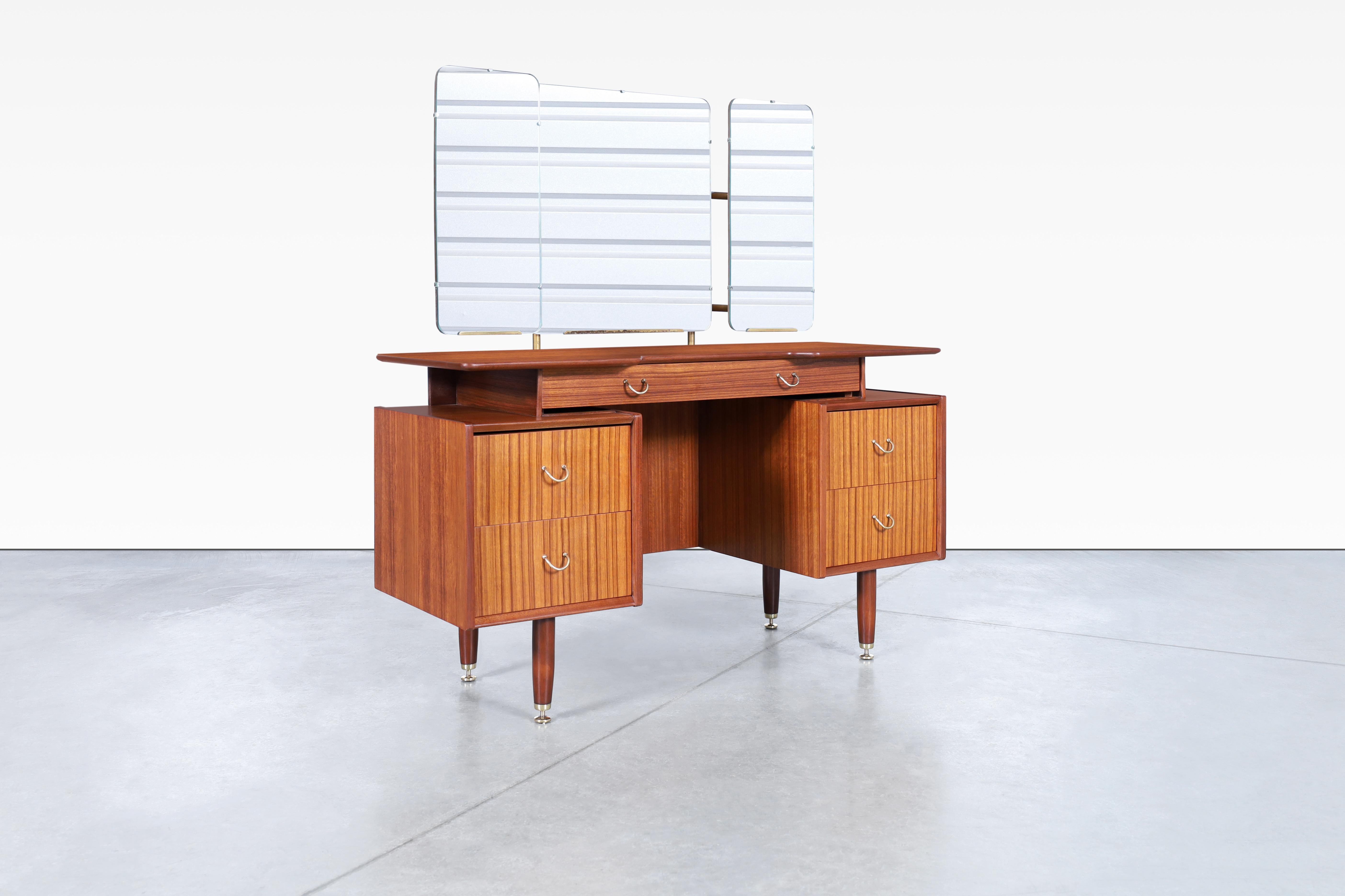 Mid-century modern vanity/desk designed by E. Gomme for G-Plan in United Kingdom, circa 1950s. This exquisite vanity is a true masterpiece and features four intricately crafted drawers and a central drawer with dividers that create separate storage