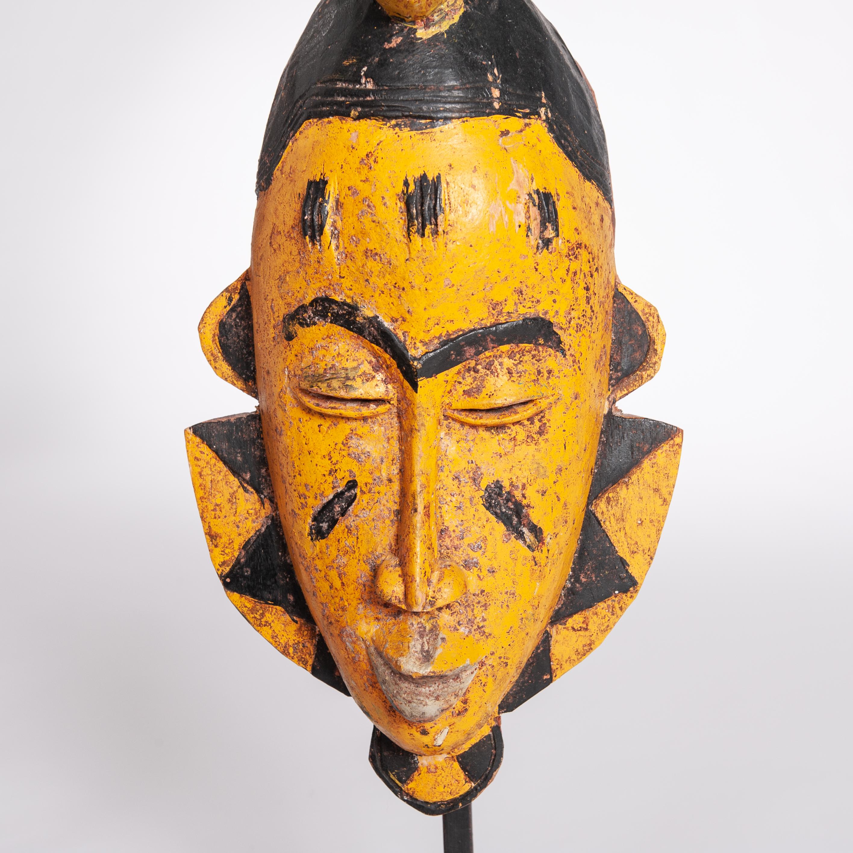 Gelb-schwarze Baoule-Stammesmaske aus der Jahrhundertmitte mit Antilopenkopfverzierung (Stammeskunst) im Angebot