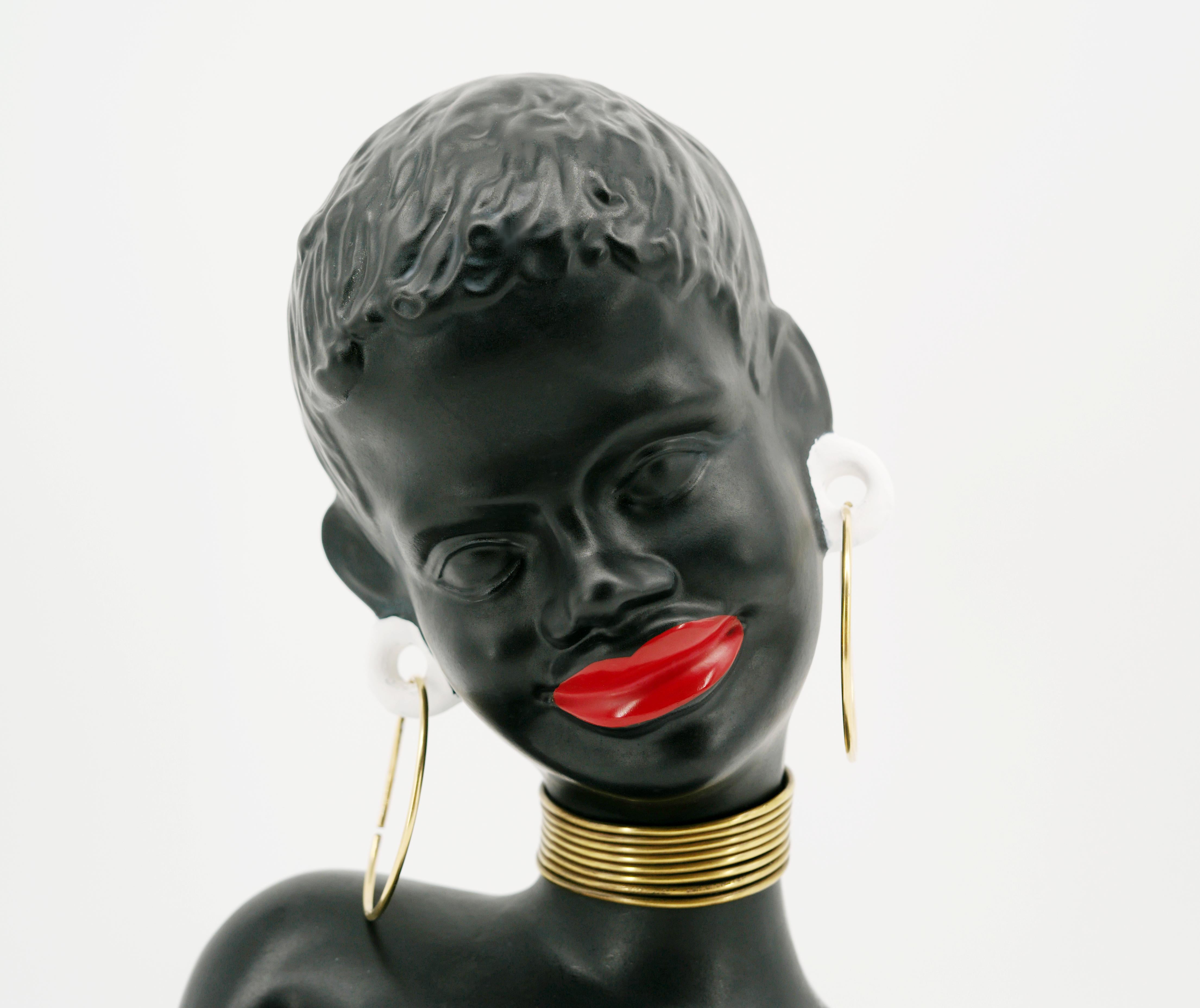 Mid-century ceramic African woman statue, Germany, 1950s. Measures: Height : 27cm - 10.6 in. ; Width : 18.8cm - 7.4 in. ; Depth : 13cm - 5.1 in. Nice and decorative for a very good quality
