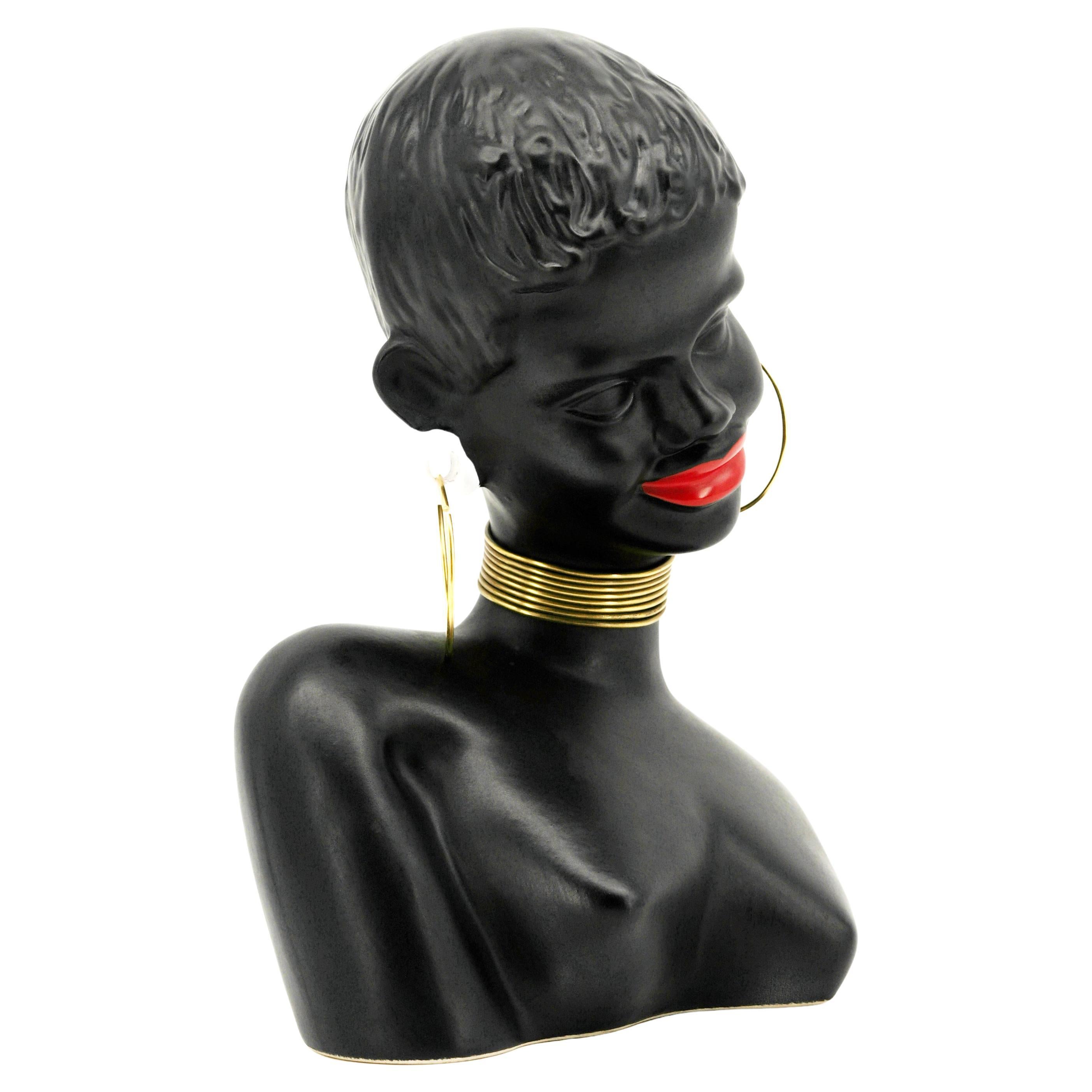 Statua di donna africana in ceramica di metà secolo, Germania, anni '50. Misure: Altezza: 29 cm; Larghezza: 14,5 cm; Profondità: 14,5 cm. Alcune lievi tracce superficiali dell'età.