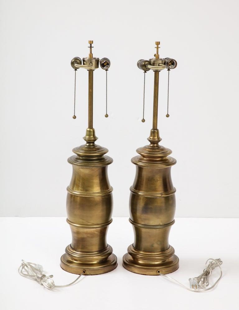 Coppia di lampade a forma di barile stilizzato di grandi dimensioni con finitura personalizzata in bronzo scuro. Le lampade sono state ricablate per essere utilizzate negli Stati Uniti; ogni presa può ospitare una lampadina da 75W al massimo.