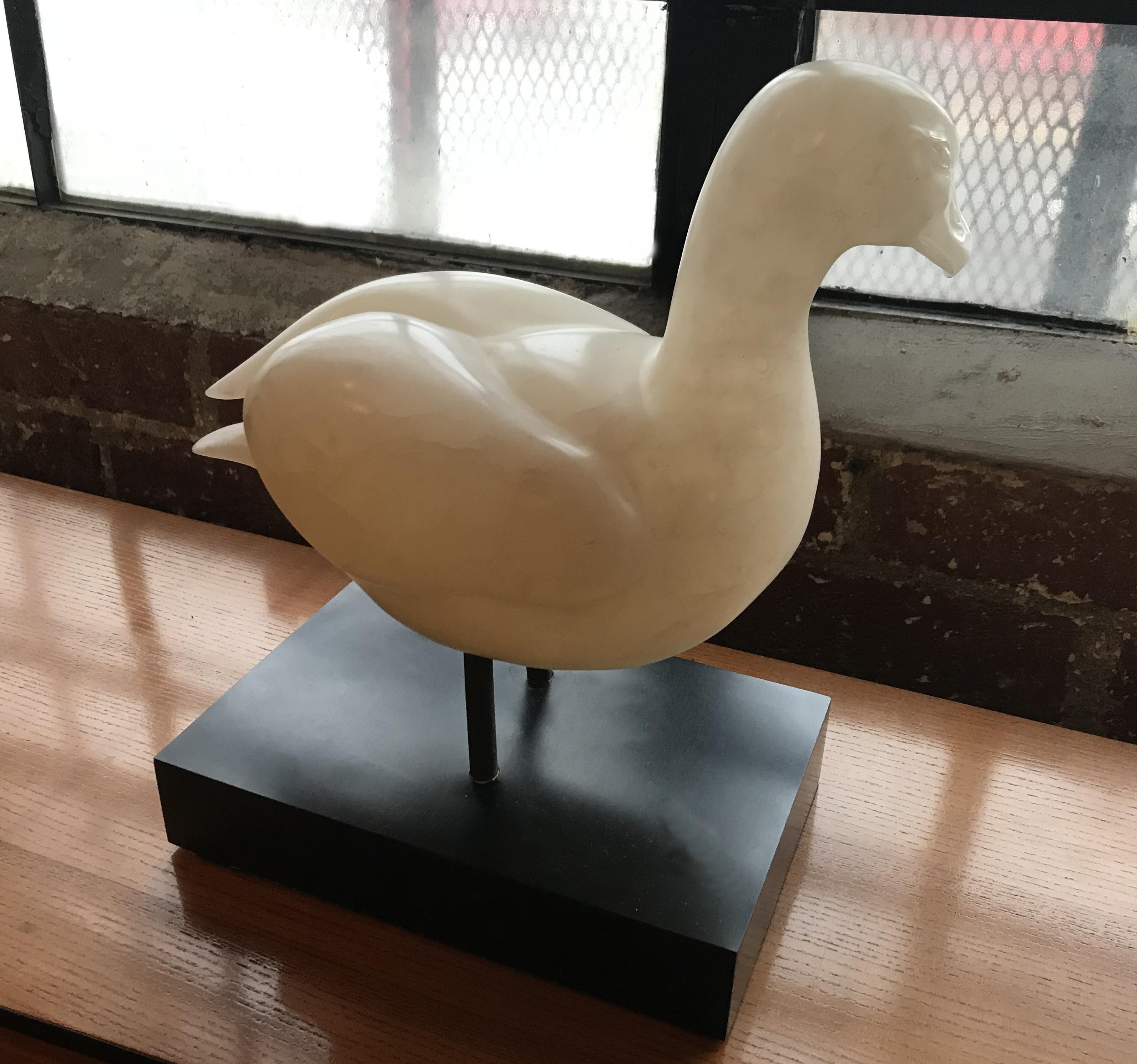 Handsome white alabaster sculpture of a duck, signed by artist T. Marvel in 1979. This serene and elegant piece is very finely executed. 
The wooden base made of black formica veneer, measures: L 11