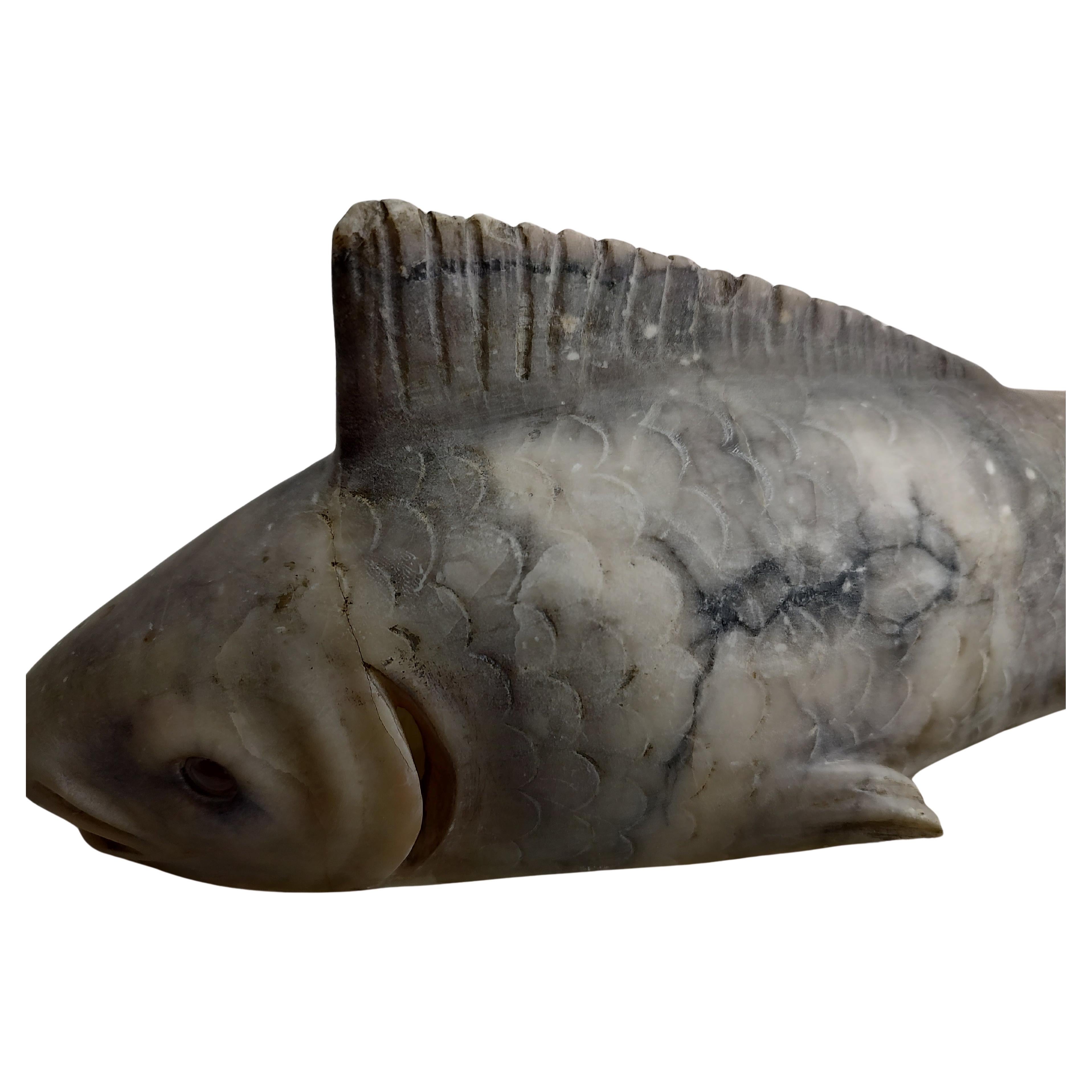 Fabulous Fisch Nachtlicht Tischlampe. Aus Alabaster in zwei Teilen geschnitzt. Der Fisch sitzt in einer geschnitzten, wiegenartigen Form und hält sie fest. Inline-Schalter und wenn er leuchtet, leuchten die Augen der Fische rot. Der Sockel wurde
