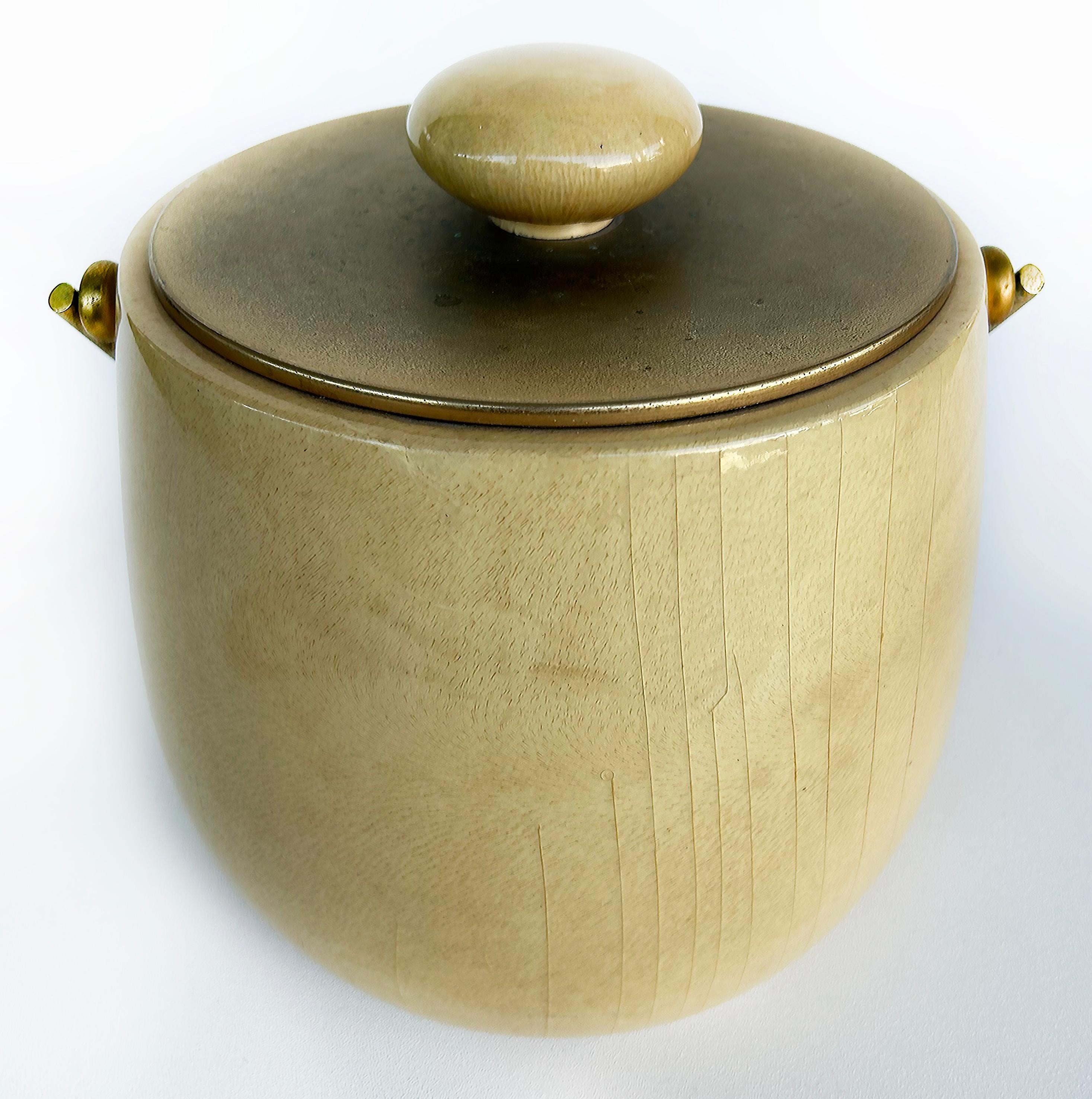 Mid-Century Aldo Tura Milano Goatskin Brass Ice Bucket, Italy circa 1970

Offered for sale is an Italian Aldo Tura Milano goatskin, brass, wood, and plastic ice bucket.  The brass handle raises and lowers and the lid is removable. The bucket retains