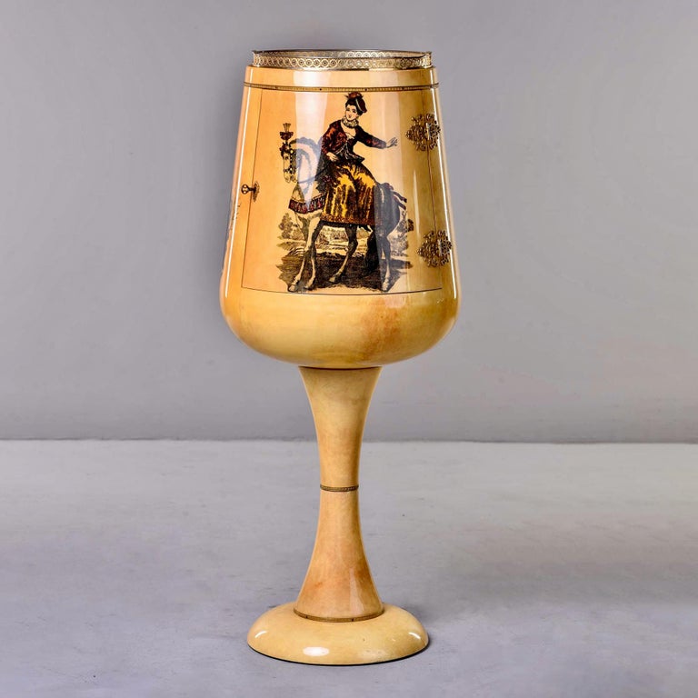 Circa 1960s pedestal style bar designed by Aldo Tura is in the form of a large stemmed goblet made of wood covered in goatskin parchment. The body of the bar is decorated all the way around with three images of 19th century figures on horseback: