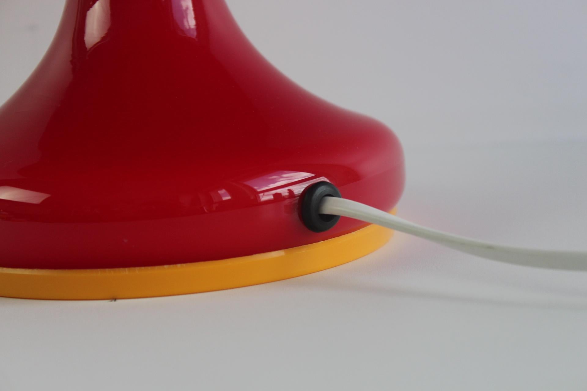 Vase en verre audacieux et expressif conçu par Štěpán Tabera pour la verrerie de Škrdlovice dans les années 1970. Avec sa silhouette dynamique et organique, son verre rouge orangé vibrant et sa base jaune contrastante, cette pièce illustre le